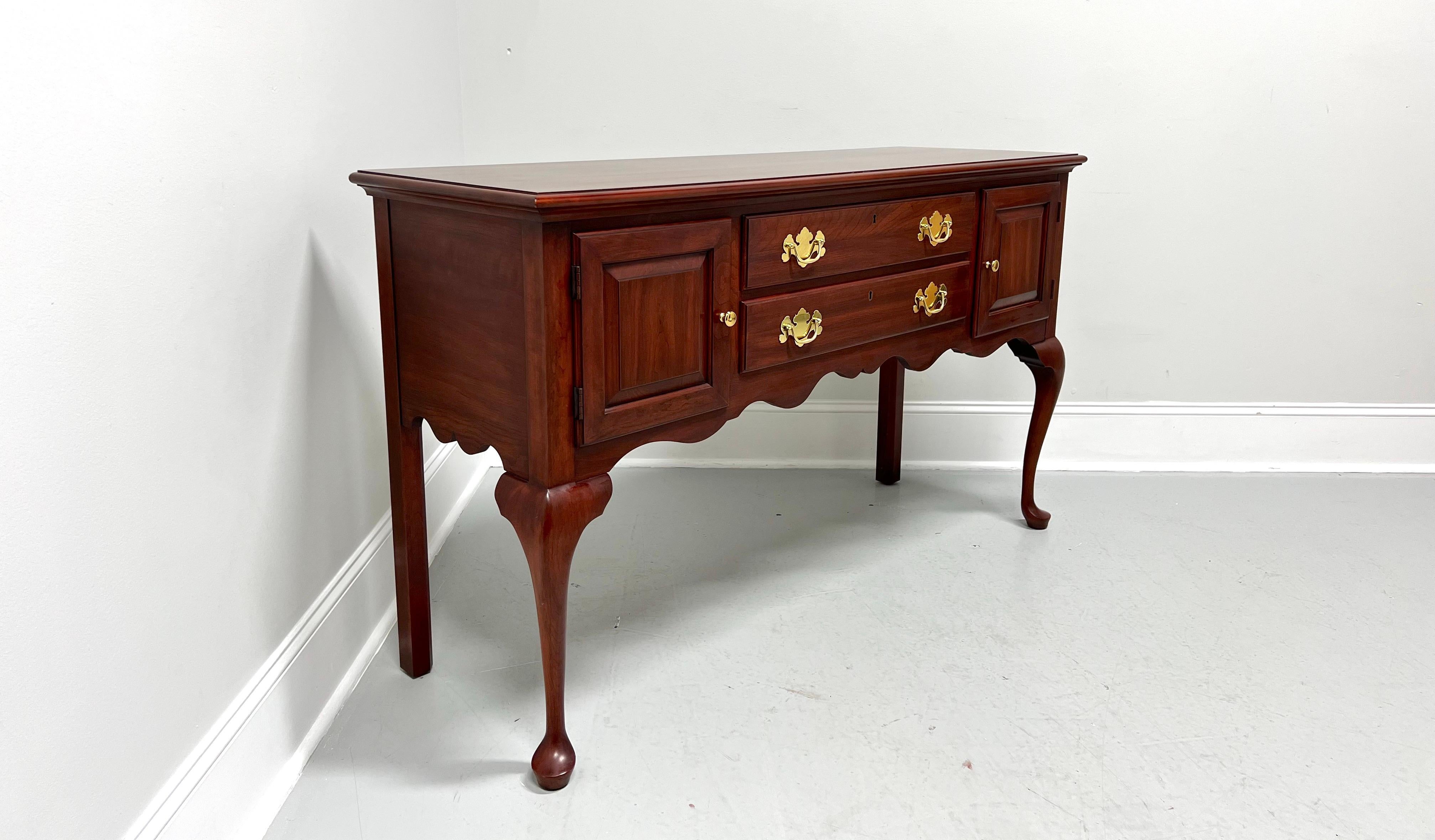 A Queen Anne style sideboard by Henkel Harris, of Winchester, Virginia, USA. Solid wild black cherry wood with brass hardware, bevel edge to the top, raised panel door fronts, carved apron, cabriole front legs with pad feet, and straight back legs.