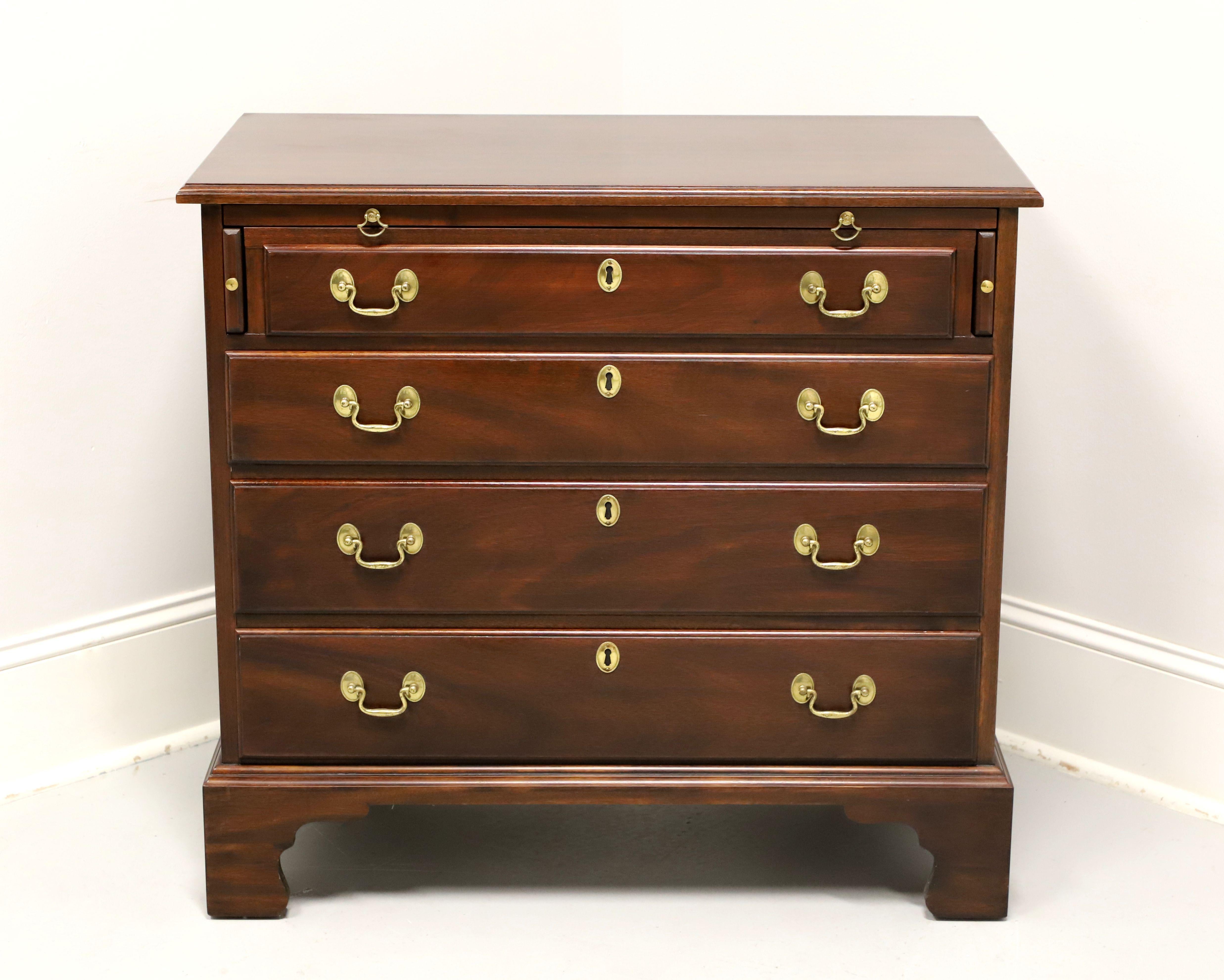 A Chippendale style chest on chest by Henkel Harris, of Winchester, Virginia, USA. Solid mahogany with brass hardware, ogee edge to the top, slide-out tray with pull-out side supports, brass side handles, ogee edge at bottom, and bracket feet.