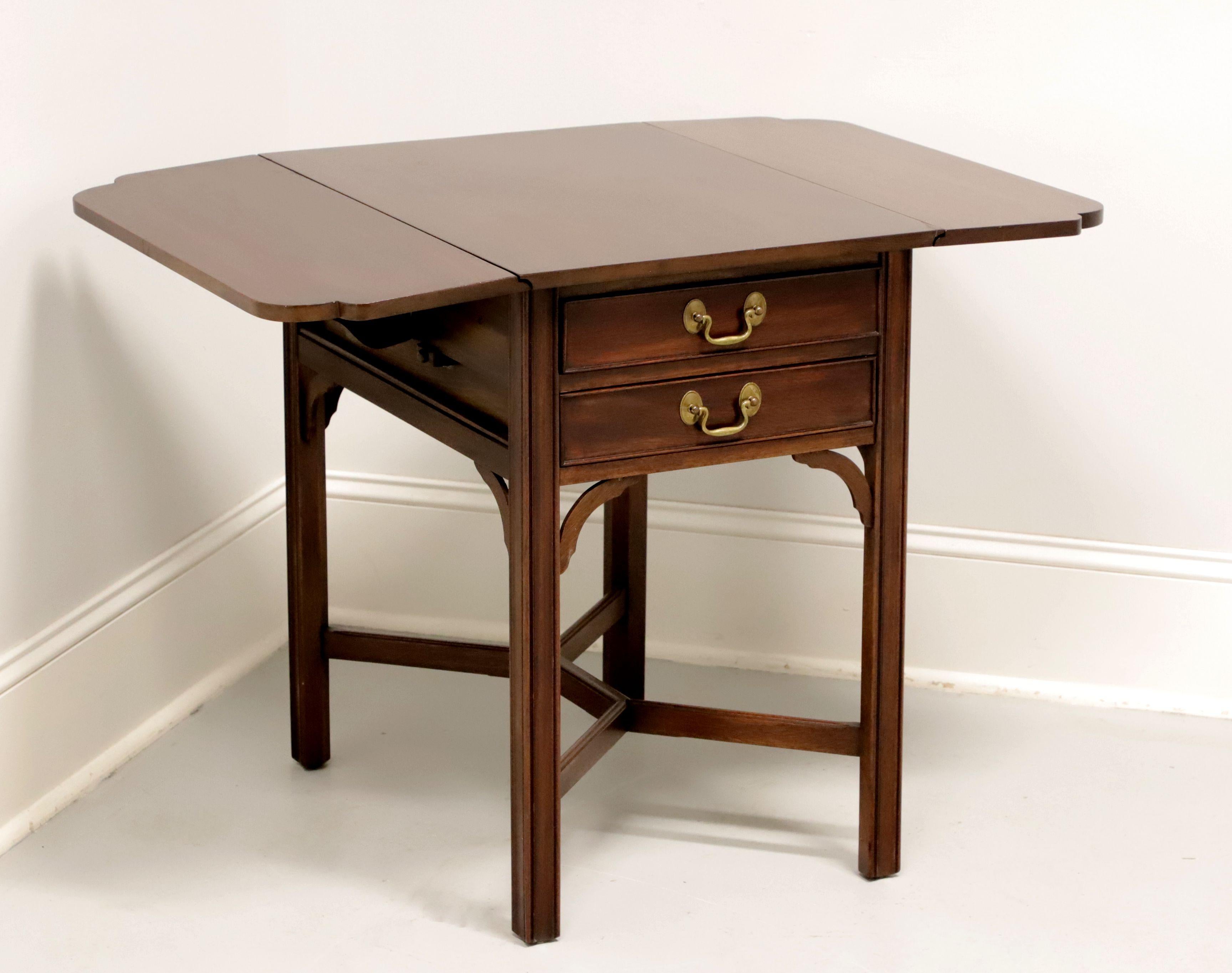 A drop-leaf end table in the Chippendale style by Henkel Harris, of Winchester, Virginia, USA. Solid mahogany with brass hardware, corner brackets, stretcher base with shaped top edge, and straight legs. Features drop leaves with rounded corners and