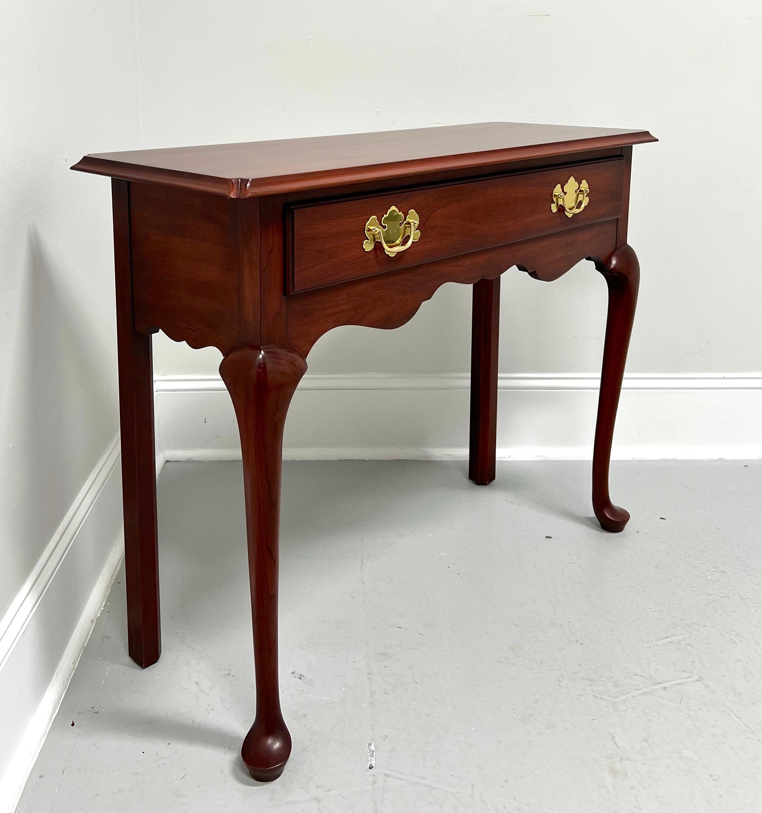 A Queen Anne style diminutive console table  by Henkel Harris, of Winchester, Virginia, USA. Solid wild black cherry wood, brass hardware, bevel edge top with clipped corners, carved apron, straight back legs, and cabriole front legs with pad feet.