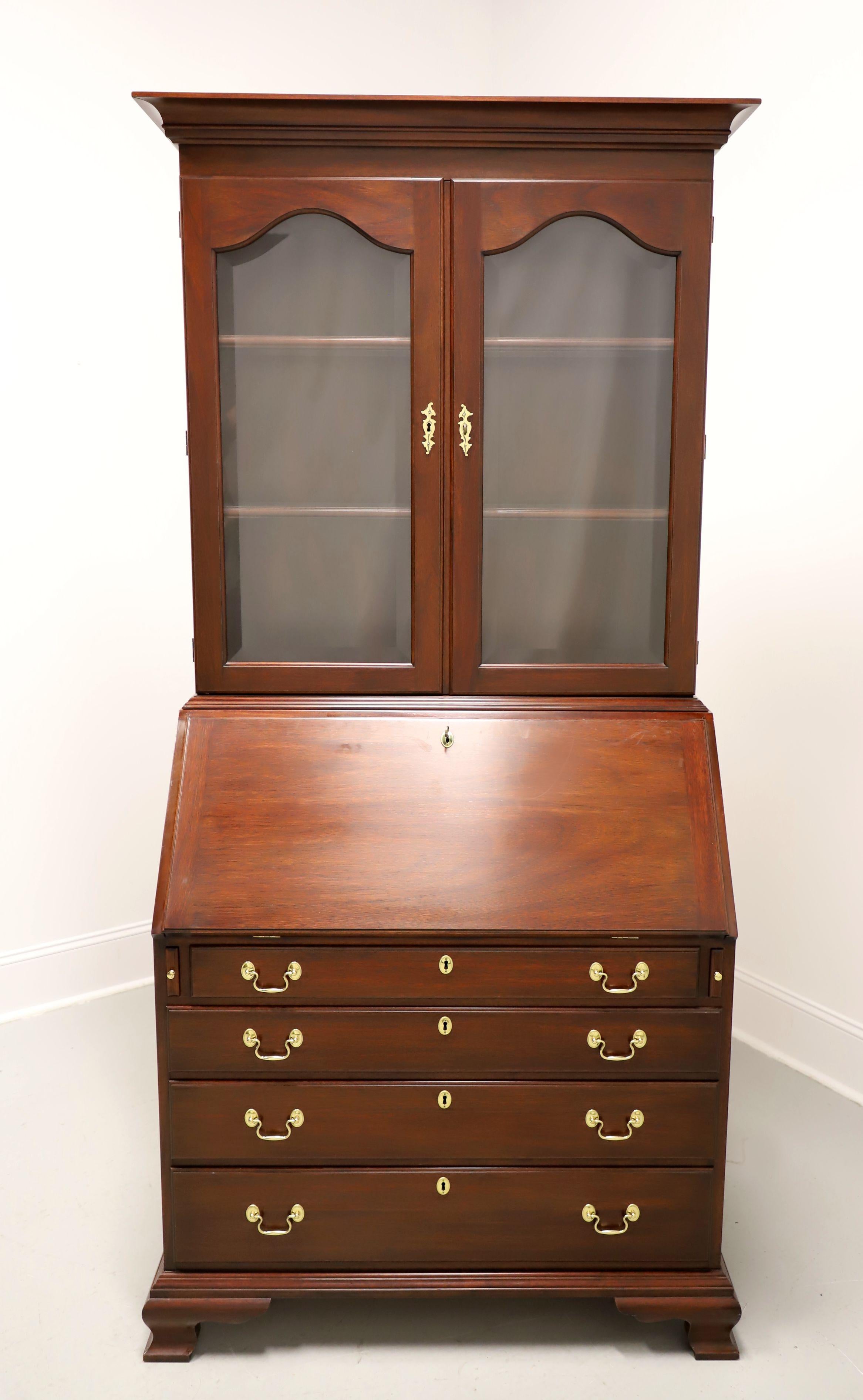 A John Hancock Chippendale style secretary desk made by Henkel Harris, of Winchester, Virginia, USA. Solid mahogany with brass hardware, crown molding at the top, and ogee bracket feet. Upper lighted display bookcase, with dimmer in a hinge,