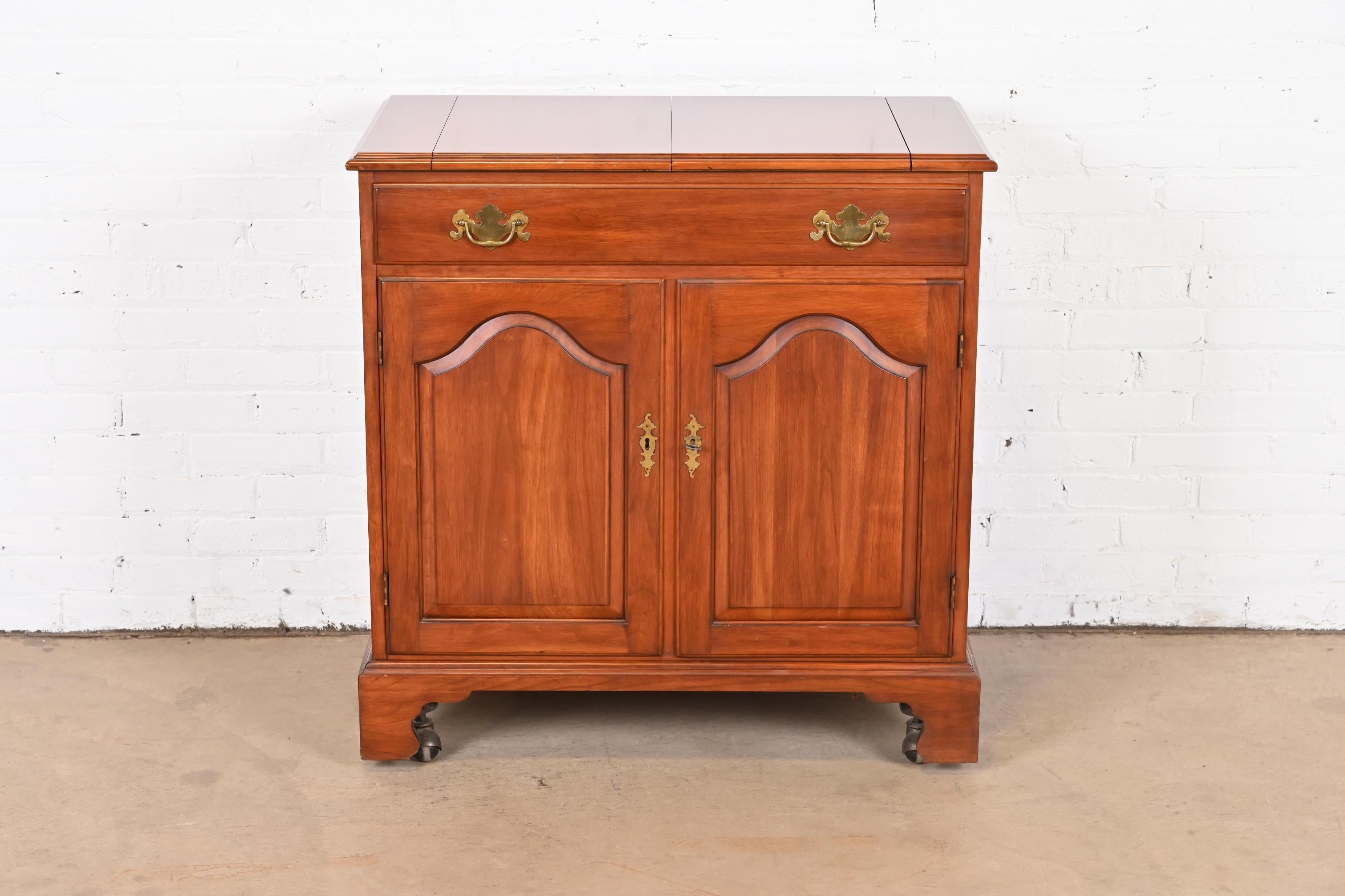 A gorgeous American Colonial or Chippendale style flip-top rolling bar cabinet

By Henkel Harris

USA, 1971

Solid wild black cherry wood, with original brass hardware. Cabinet locks, and key is included.

Measures: 34.38