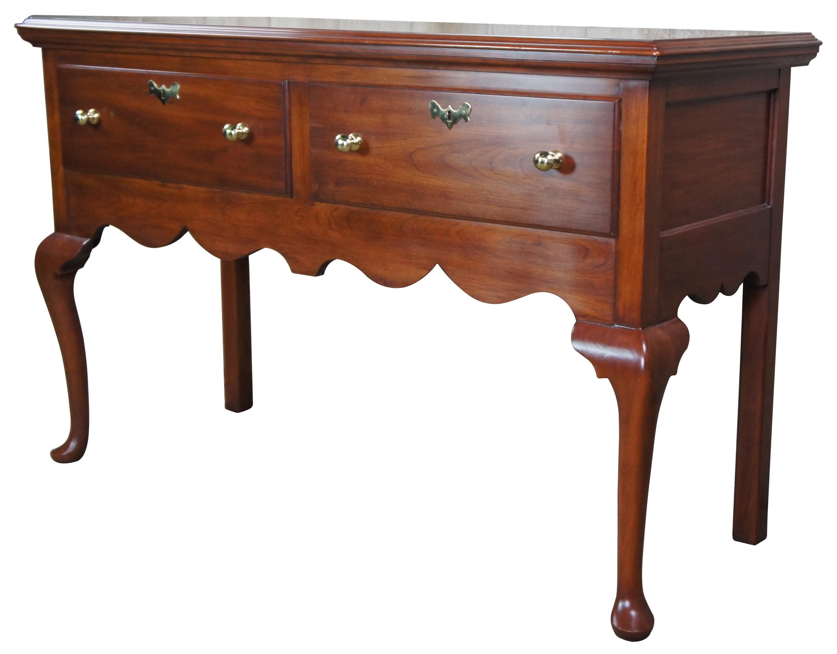 Vintage 1986 Hinkel Harris Jamestown Colony Wild Black Cherry buffet or sideboard. A rectangular form with 2 large drawers with brass knobs and colonial escutcheons over a serpentine cut apron. Supported by cabriole legs with pad feet and squared