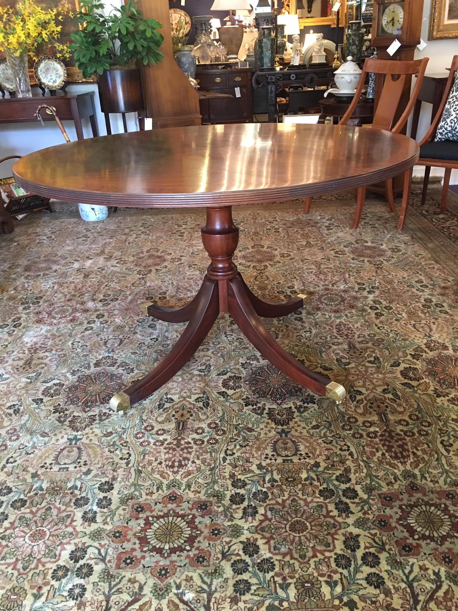 This beautiful Henkle-Harris centre table comes with a custom table pad (not pictured) . It was made in Winchester, Virgina and is dated 1996. This would make a gracious centre table. It has a single pedestal, brass feet, and casters.