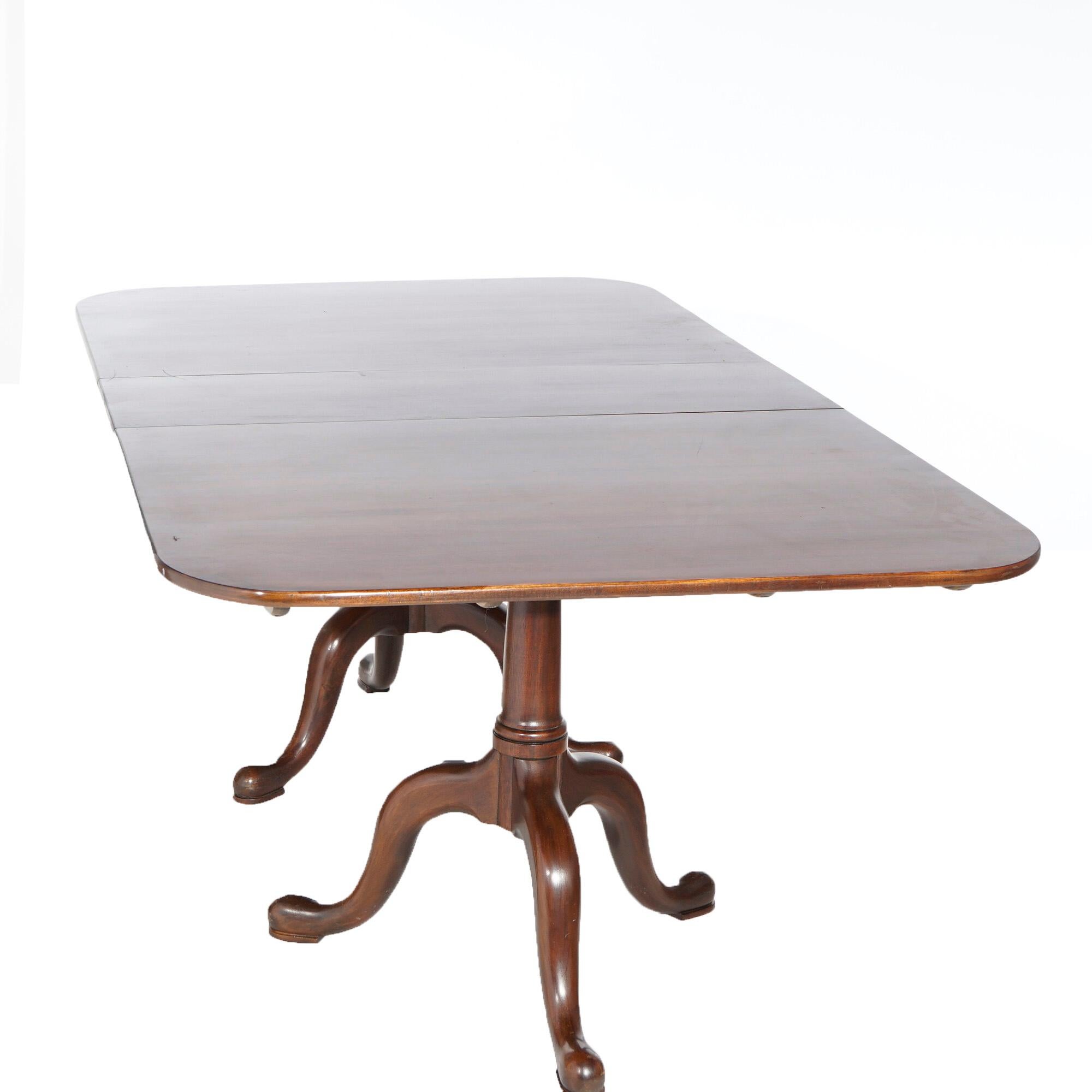 A Chippendale style extension dining table by Henkel Harris Virginia Galleries offers mahogany construction with double pedestals raised on tripod cabriole legs with pad feet, accepts single leaf, maker label as photographed, 20th century. 