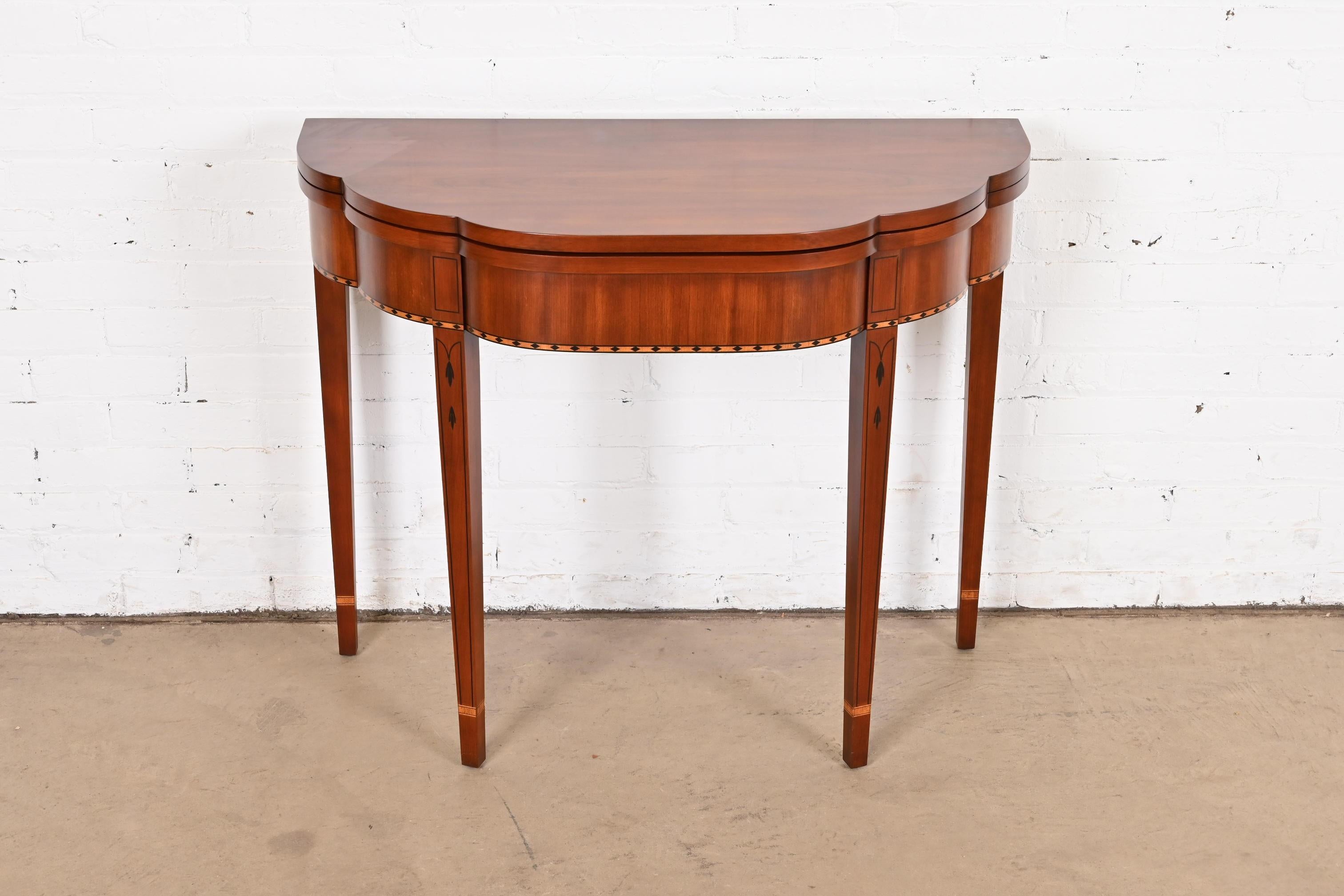 A gorgeous Federal or Hepplewhite style flip top demilune console game table

By Henkel Harris

USA, 1990s

Beautiful cherry wood, with inlaid ebony and satinwood marquetry.

Measures: 36