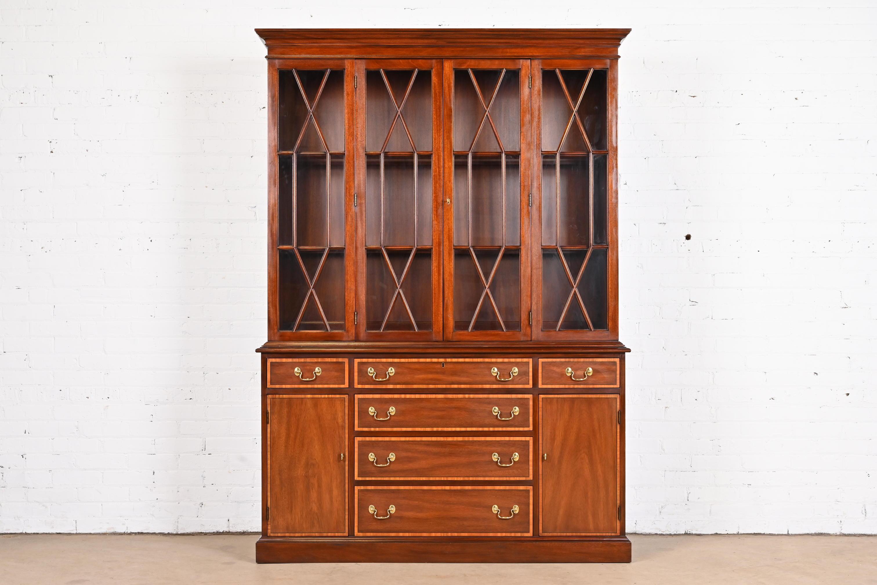 A gorgeous Georgian or Chippendale style lighted breakfront bookcase or dining cabinet

By Henkel Harris

USA, 1986

Mahogany, with satinwood banding, mullioned glass front doors, and original brass hardware. Lights have been tested and are
