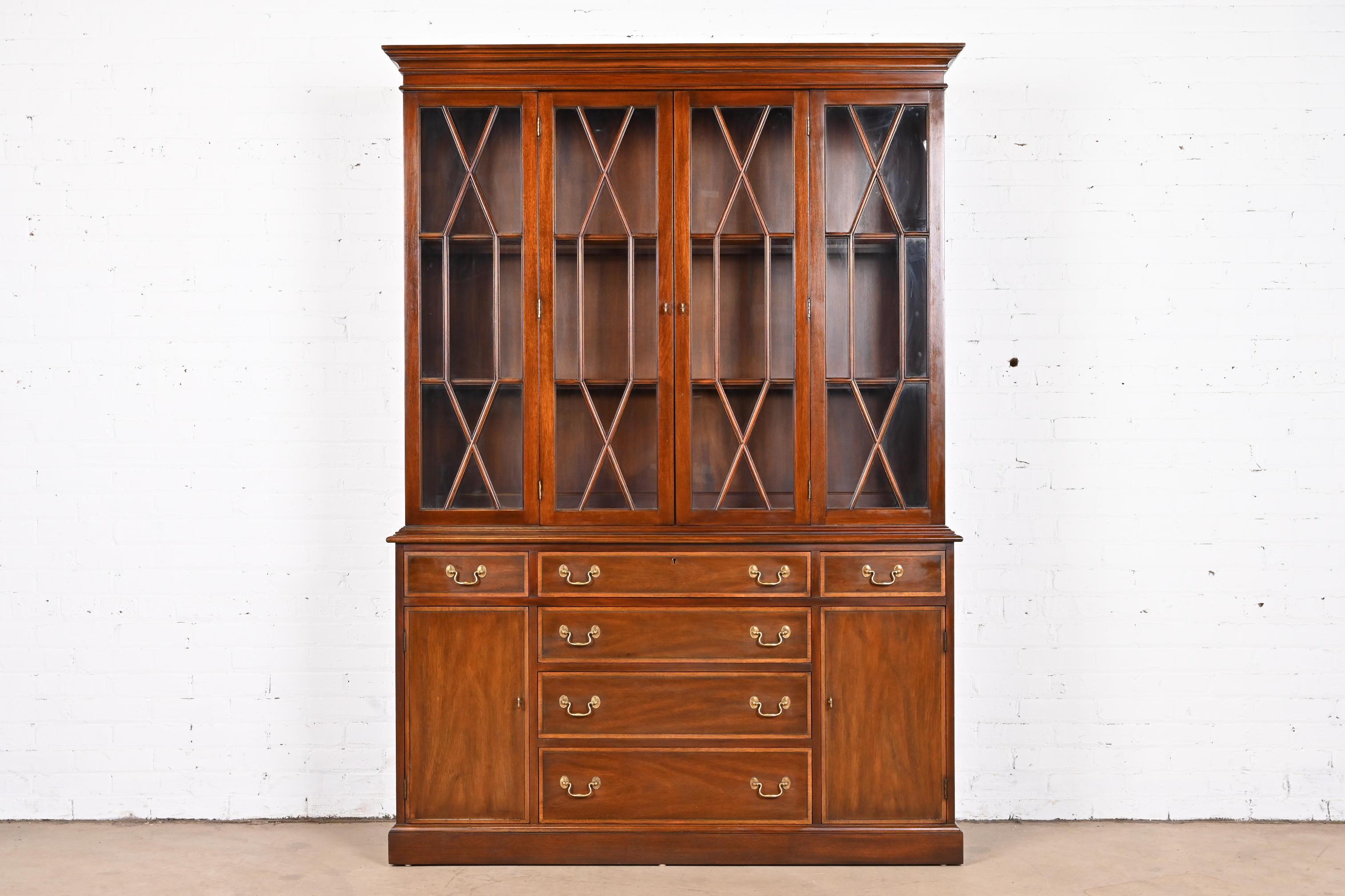 A gorgeous Georgian or Chippendale style lighted breakfront bookcase or dining cabinet

By Henkel Harris

USA, 1978

Mahogany, with satinwood banding, mullioned glass front doors, and original brass hardware. Lights have been tested and are