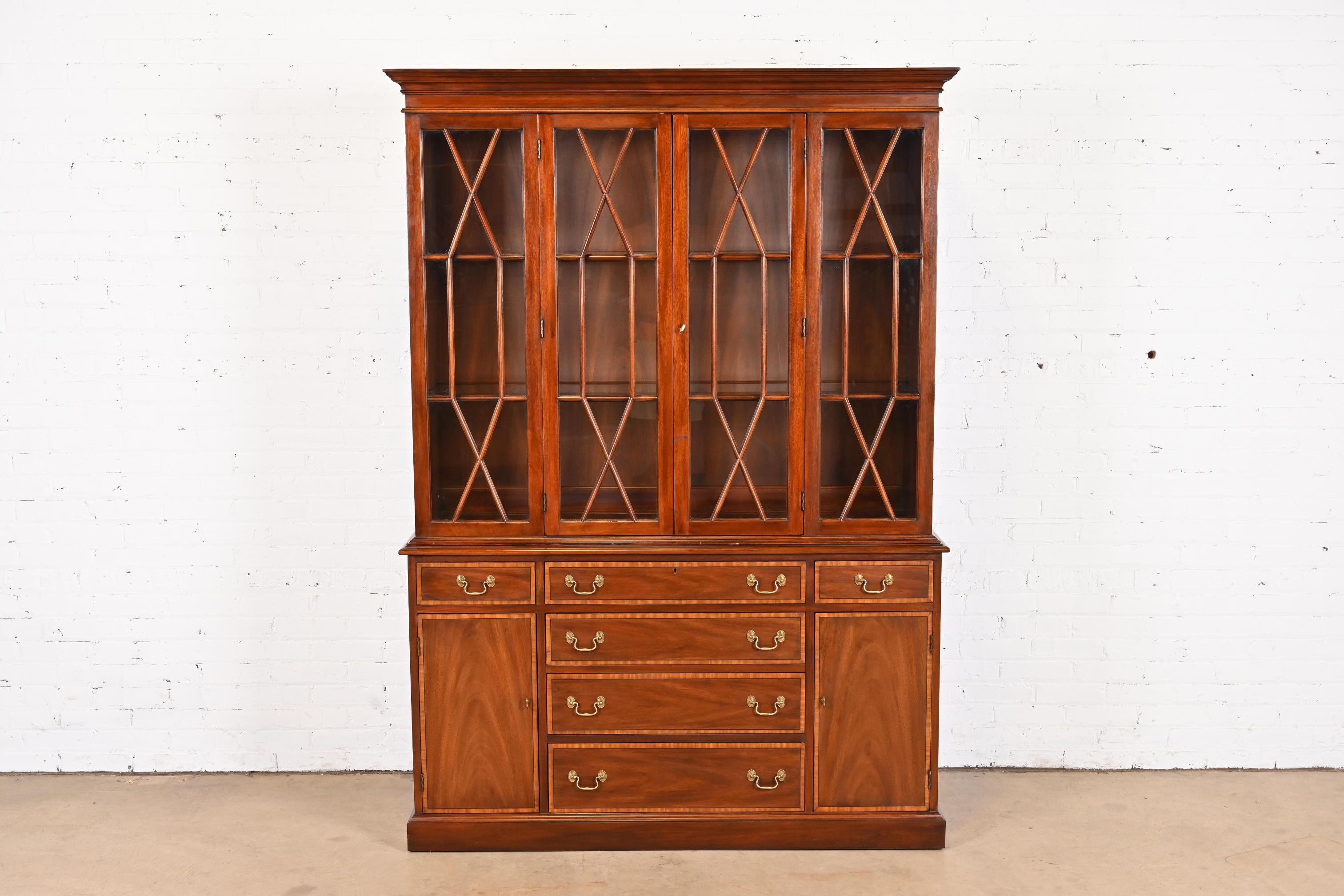 A gorgeous Georgian or Chippendale style lighted breakfront bookcase or dining cabinet

By Henkel Harris

USA, 1980

Mahogany, with satinwood banding, mullioned glass front doors, and original brass hardware. Lights have been tested and are