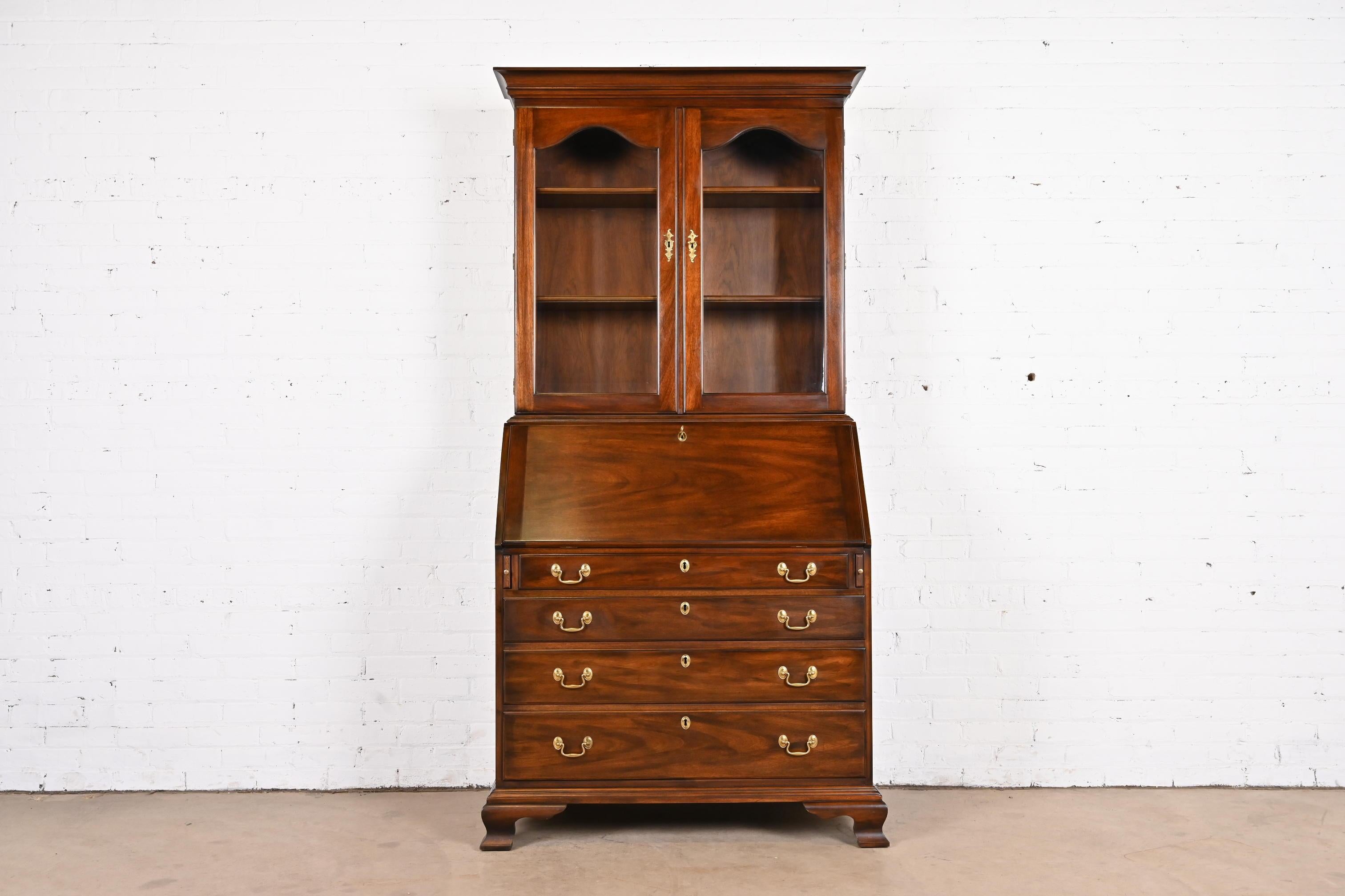 A gorgeous Georgian or Chippendale style bureau with drop front secretary desk and bookcase hutch top

By Henkel Harris

USA, 1970

Carved solid mahogany, with glass front doors and original brass hardware. Cabinet locks, and original key is