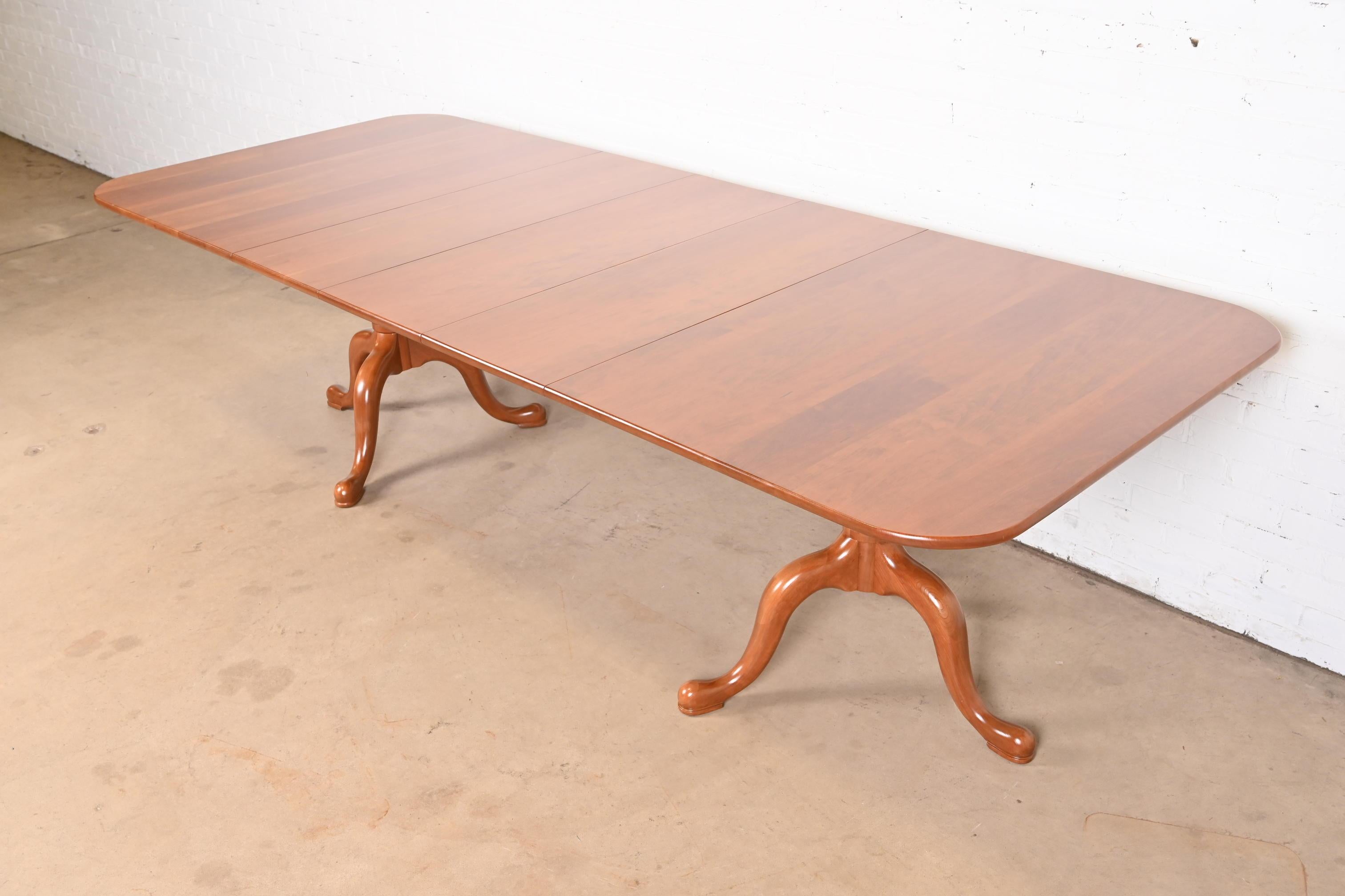 An exceptional Georgian or Queen Anne style solid cherry wood double pedestal extension dining table

By Henkel Harris

USA, 1980s

Measures: 66