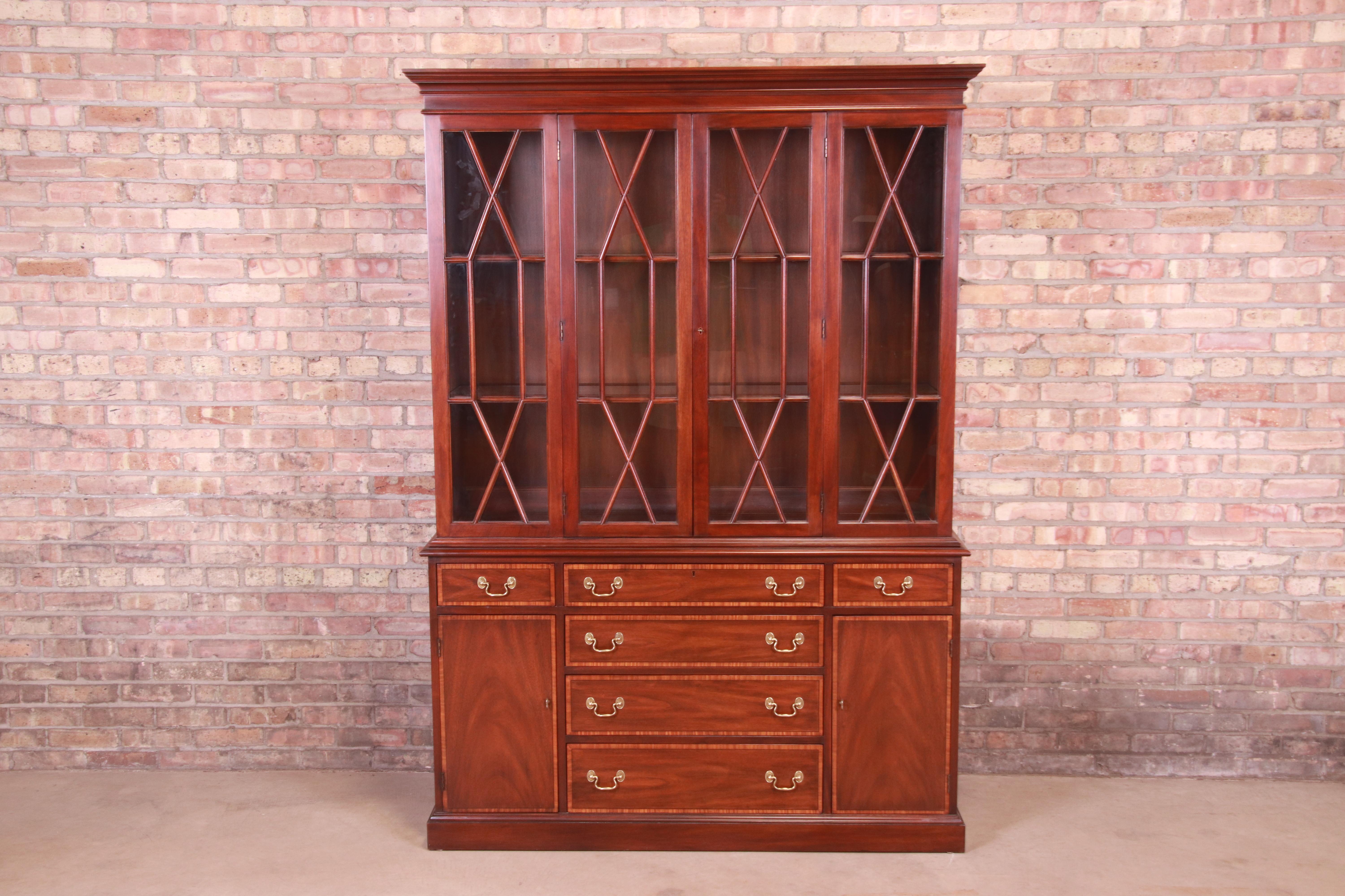 A gorgeous Georgian style lighted breakfront bookcase cabinet

By Henkel Harris

USA, 1980

Book-matched flame mahogany with satinwood banding, mullioned glass front doors, and original brass hardware.

Measures: 55