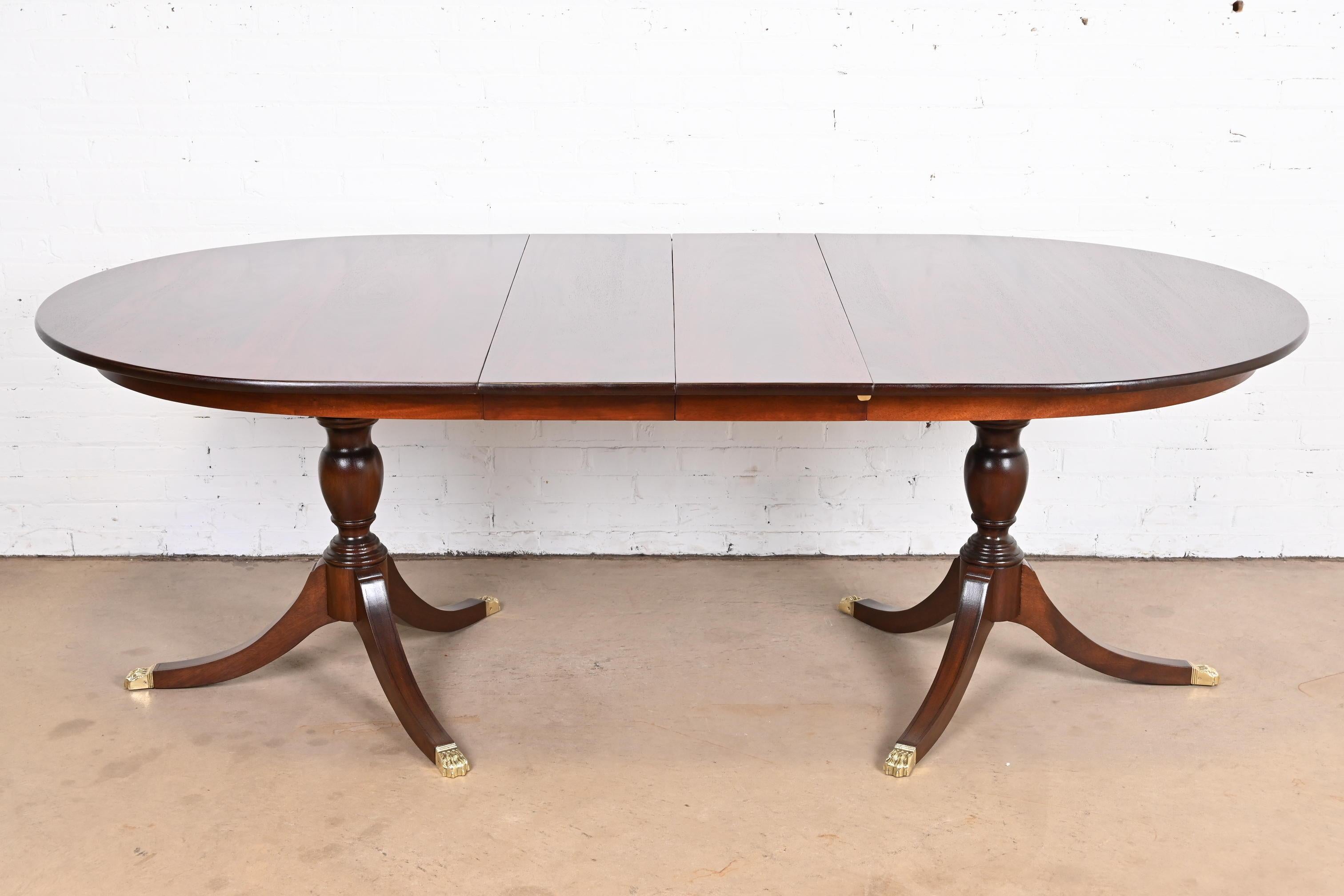 An exceptional Georgian or Regency style double pedestal extension dining table

By Henkel Harris

USA, circa 1960s

Gorgeous solid mahogany, with carved pedestals and brass capped paw feet.

Measures: 65.75