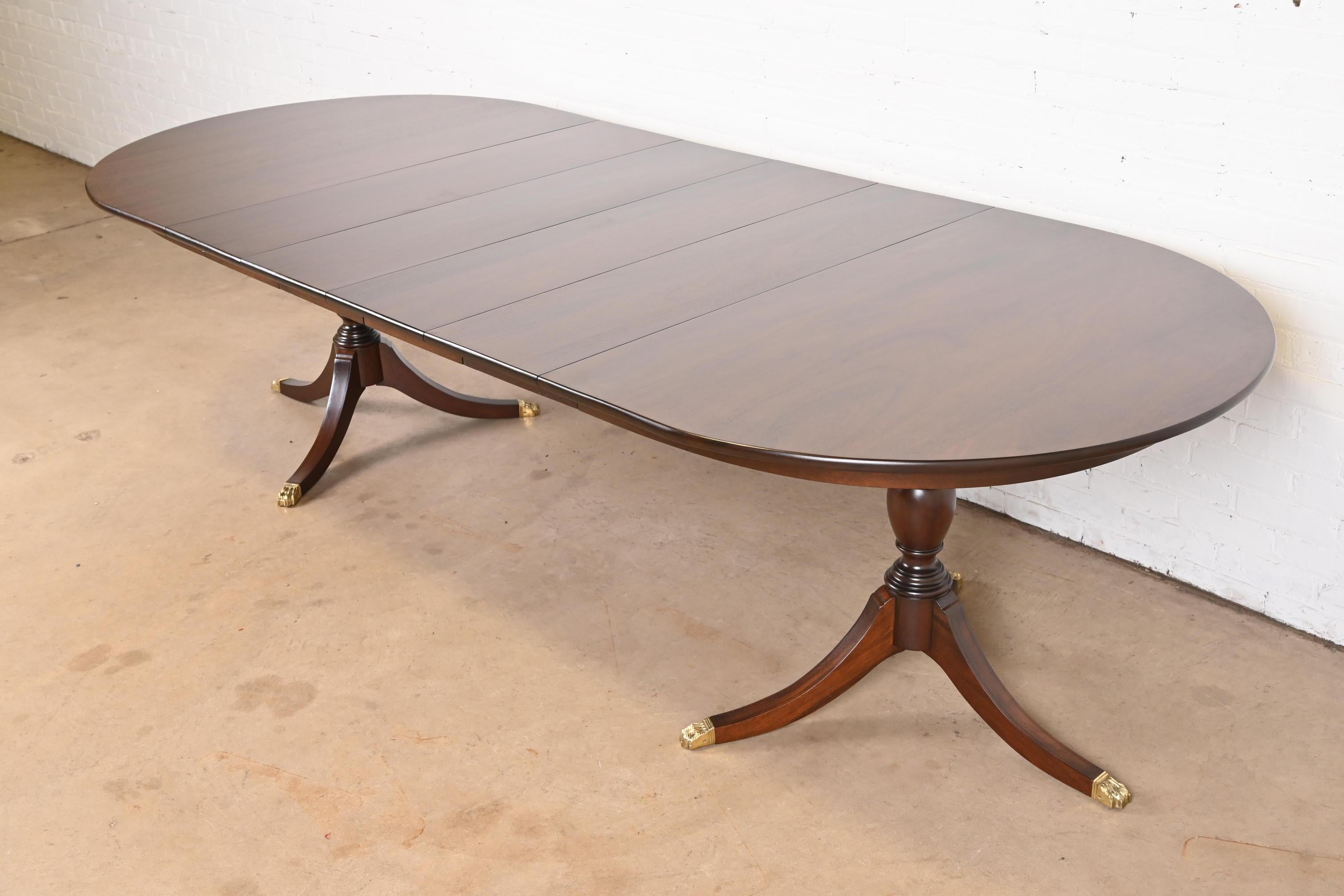 An exceptional Georgian or Regency style double pedestal extension dining table

By Henkel Harris

USA, 1971

Gorgeous solid mahogany, with carved pedestals and brass-capped paw feet.

Measures: 66.25