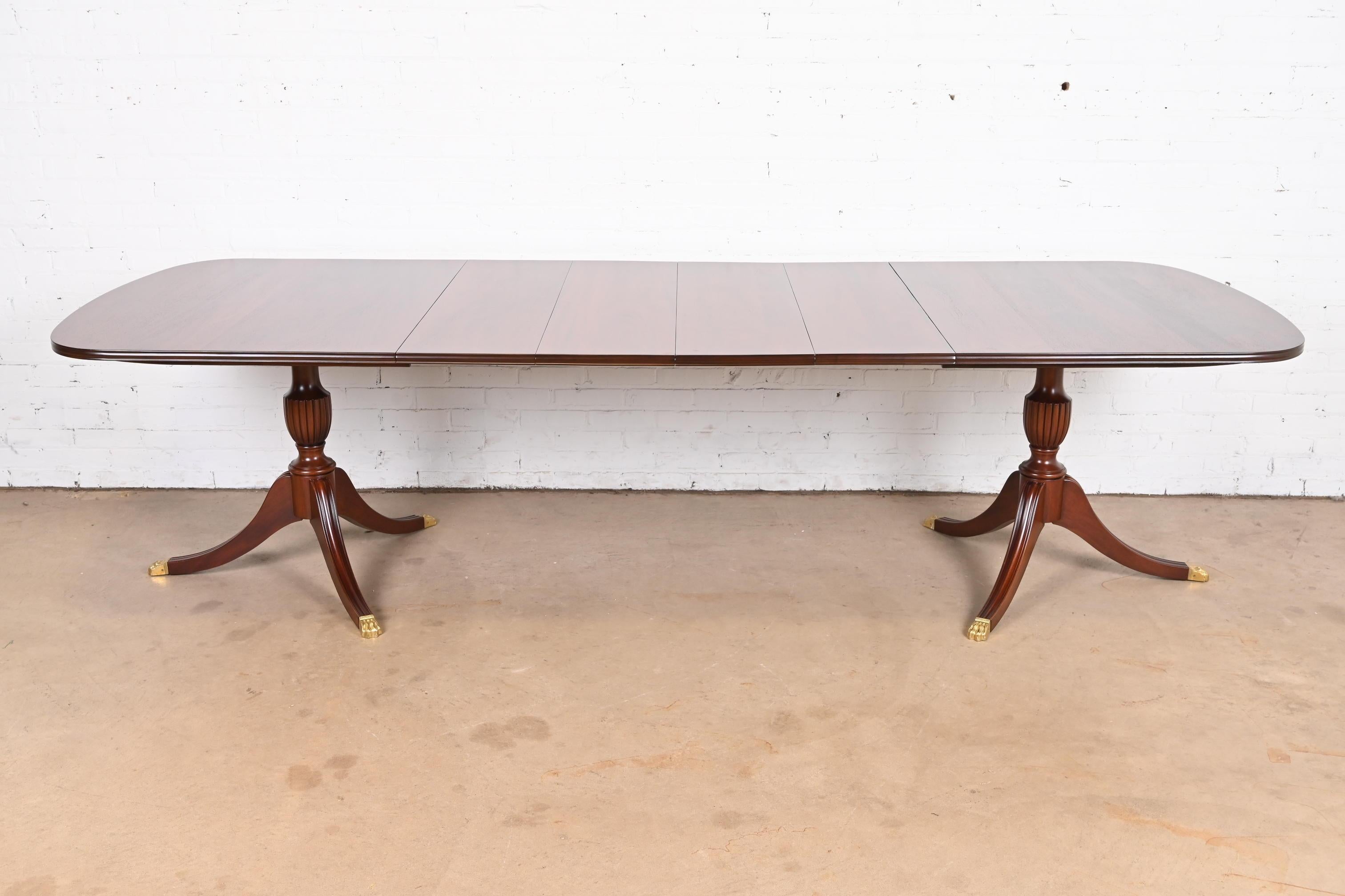 An exceptional Georgian or Regency style double pedestal extension dining table

By Henkel Harris

USA, 1990

Gorgeous solid mahogany, with carved pedestals and brass-capped paw feet.

Measures: 68