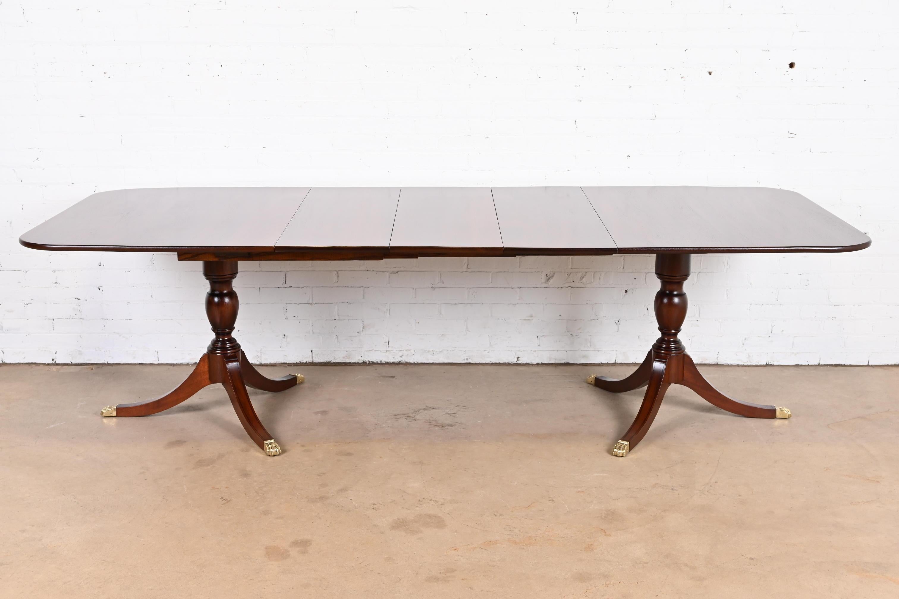 An exceptional Georgian or Regency style double pedestal extension dining table

By Henkel Harris

USA, 1971

Gorgeous solid mahogany, with carved pedestals and brass-capped paw feet.

Measures: 66