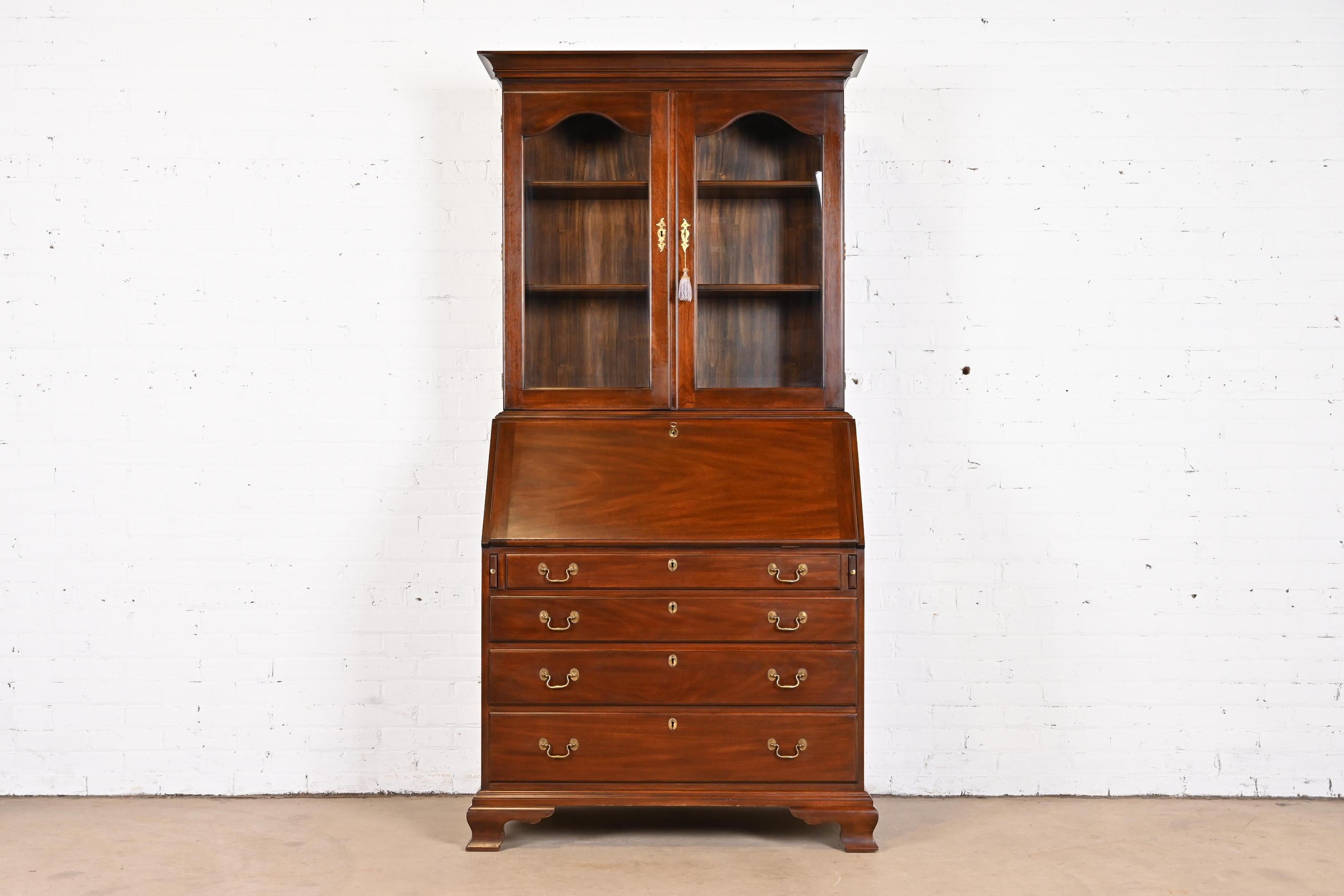 A gorgeous Georgian or Chippendale style bureau with drop front secretary desk and bookcase hutch top

By Henkel Harris

USA, Circa 1977

Carved solid mahogany, with glass front doors and original brass hardware. Cabinet locks, and original