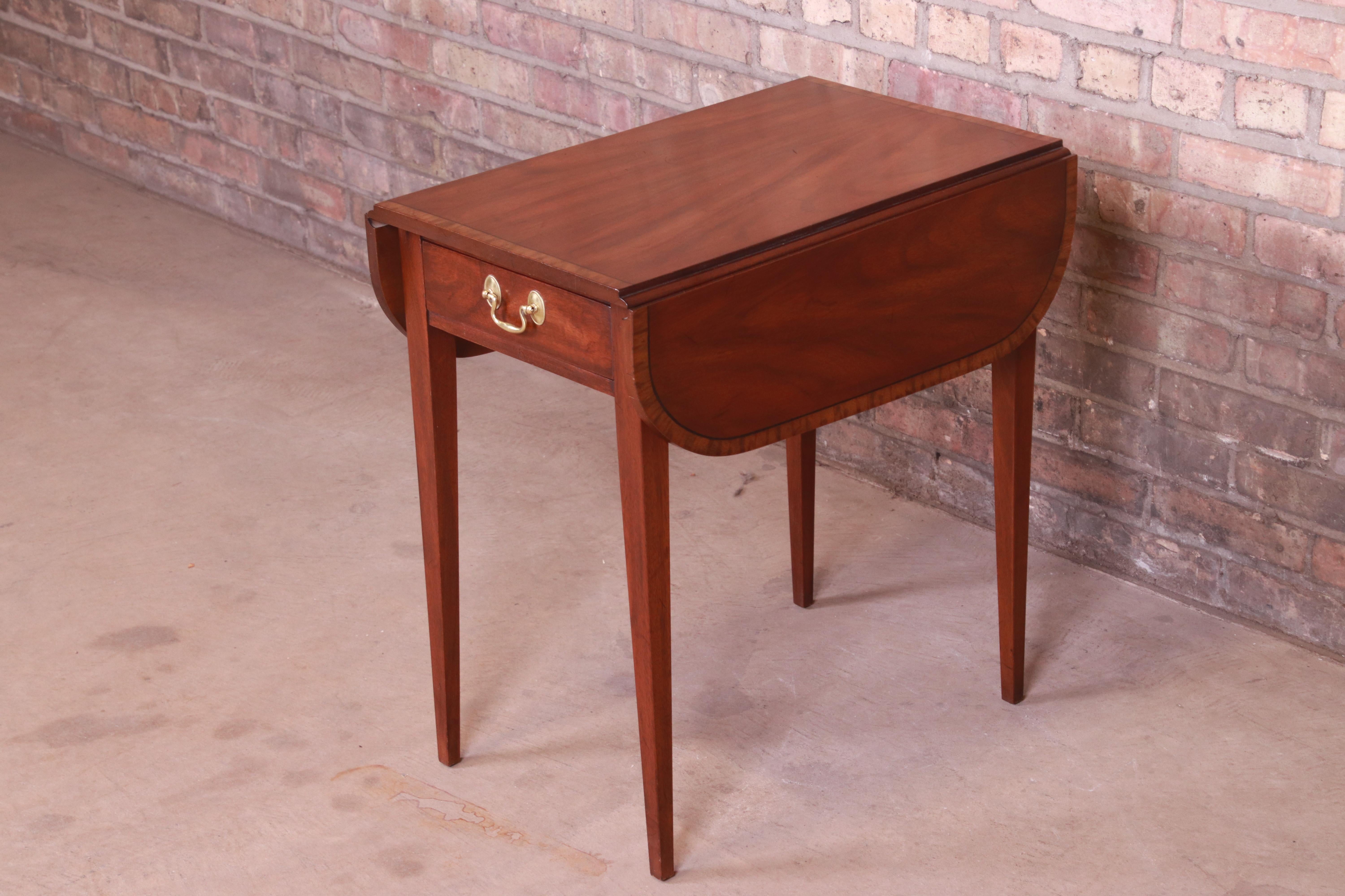 A gorgeous Georgian style Pembroke nightstand or end table

By Henkel Harris,

USA, circa 1990s

Mahogany, with original brass hardware.

Measures: 15.25