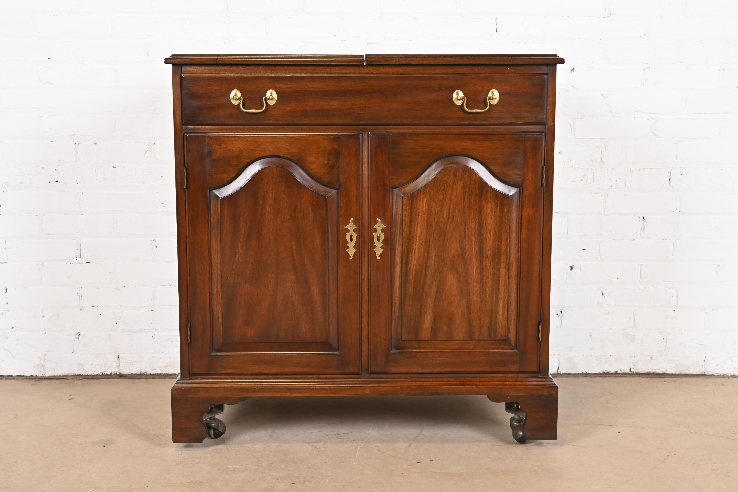 A gorgeous Georgian or Chippendale style flip-top rolling bar cabinet

By Henkel Harris

USA, 1973

Solid mahogany, with original brass hardware. Cabinet locks, and key is included.

Measures: 34.25