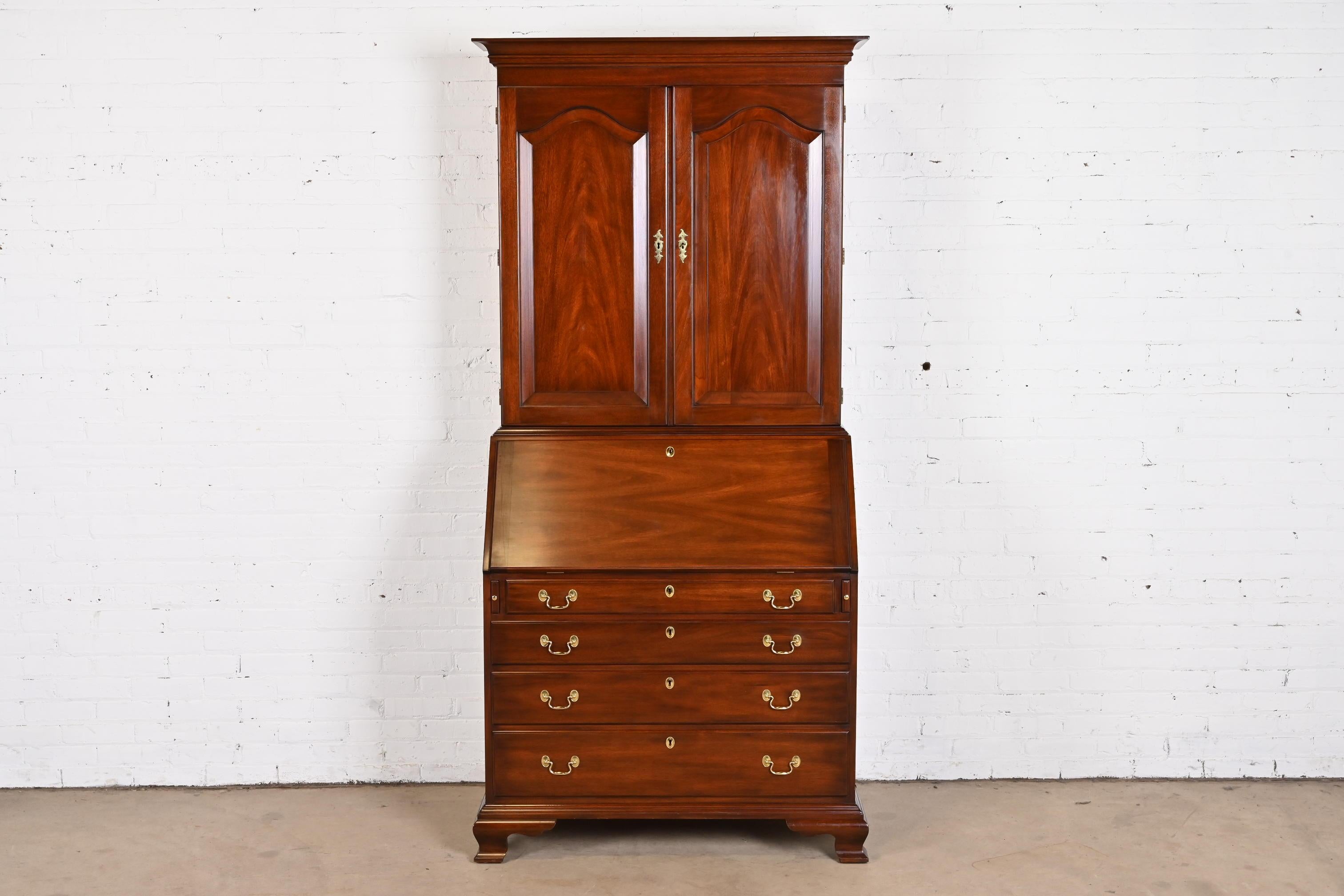 A gorgeous Georgian or Chippendale style bureau with slant front secretary desk and bookcase hutch

By Henkel Harris

USA, 1980s

Carved solid mahogany, with original brass hardware. Desk and drawers lock, and key is included.

Measures: