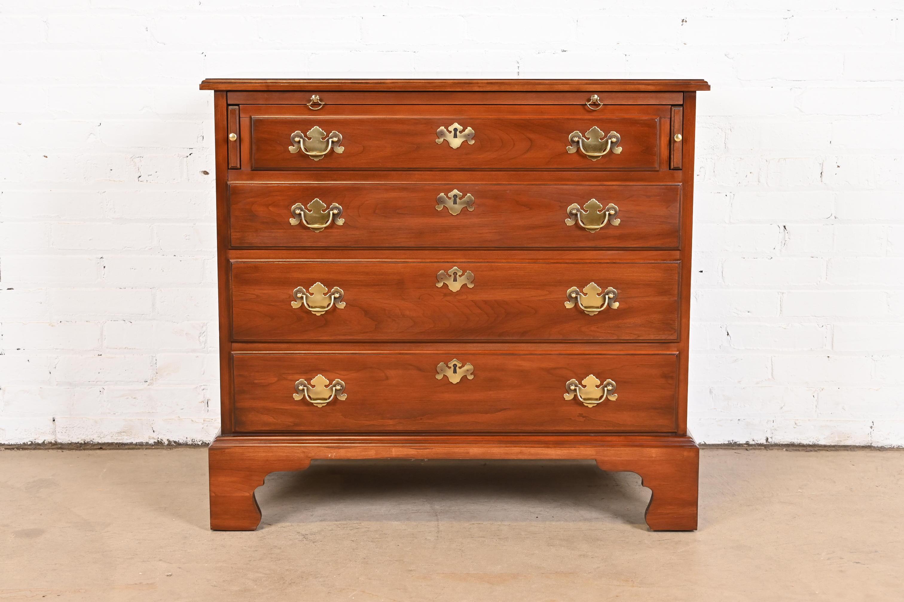 A gorgeous Georgian or Chippendale style four-drawer bachelor chest or bedside chest with pull-out tray

By Henkel Harris

USA, 1977

Solid cherry wood, with original brass hardware.

Measures: 33.25