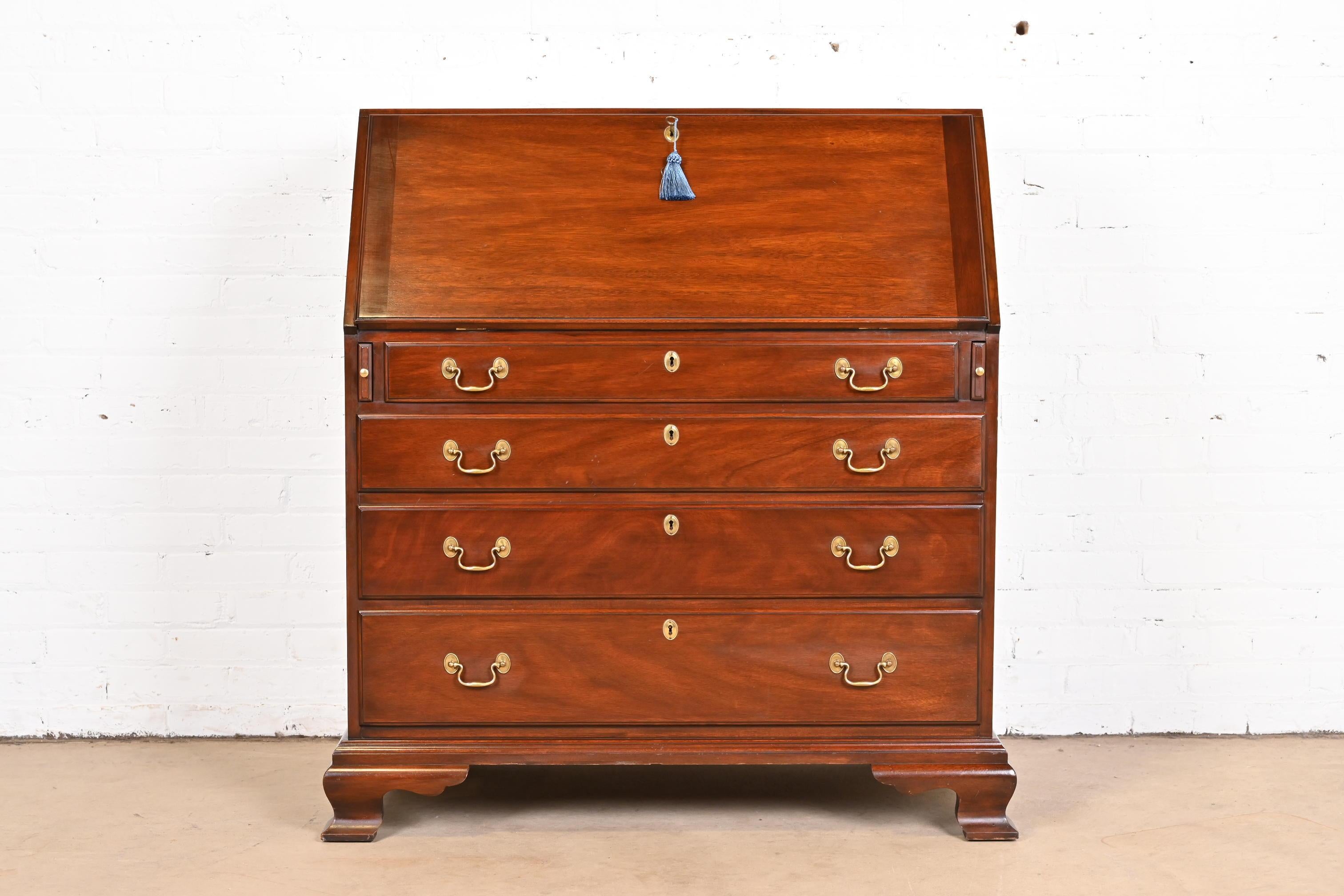 A gorgeous Georgian or Chippendale style bureau with slant front writing desk or secretary desk

By Henkel Harris

USA, 1981

Carved solid mahogany, with original brass hardware. Desk and drawers lock, and key is included.

Measures: 38