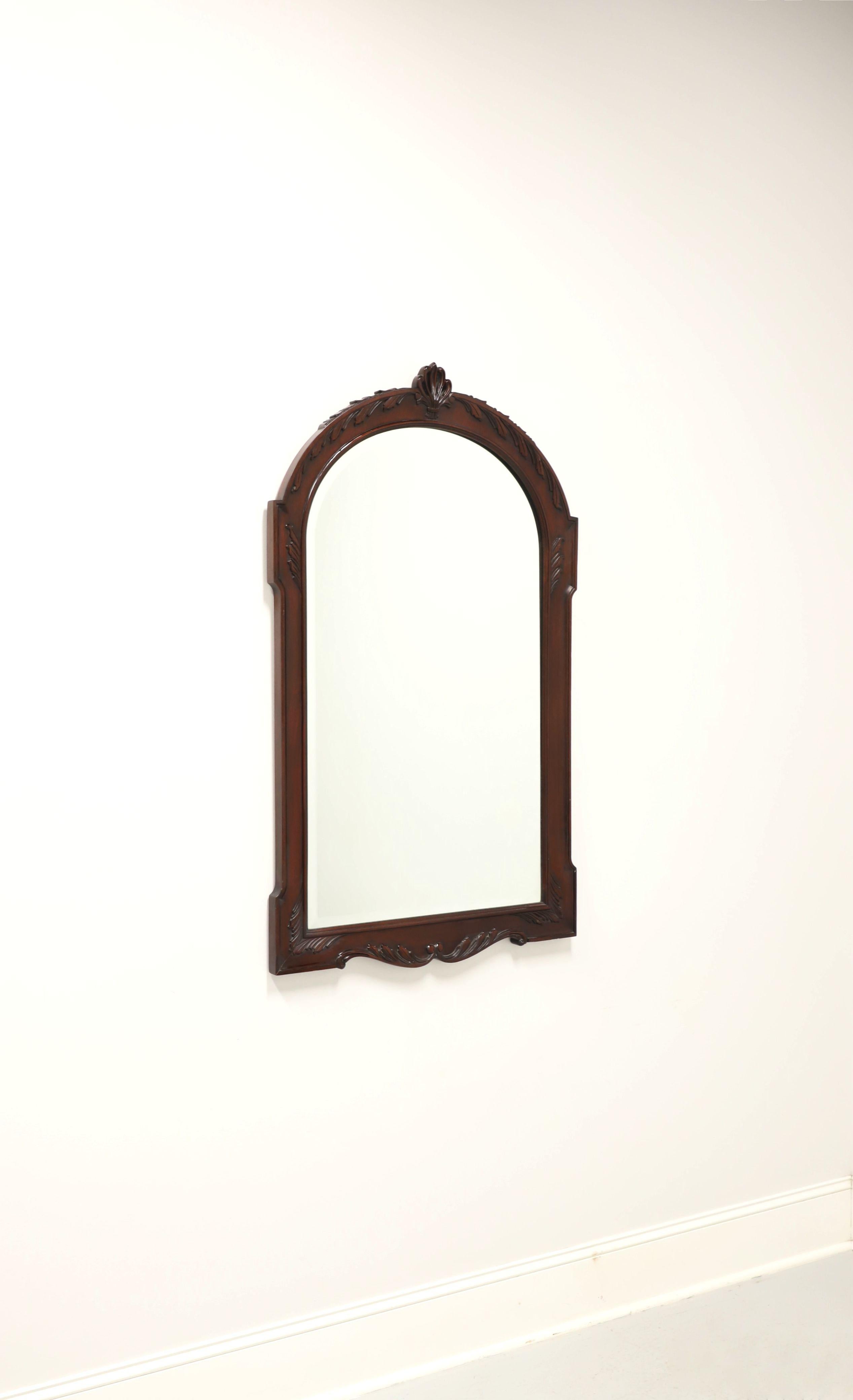 A Traditional style wall mirror by Henkel Harris, of Winchester, Virginia, USA. Beveled edge mirrored glass, solid mahogany frame, decoratively carved with arched top and center fleur. Made circa 1997.

Style #: H-30, Finish #: 29 