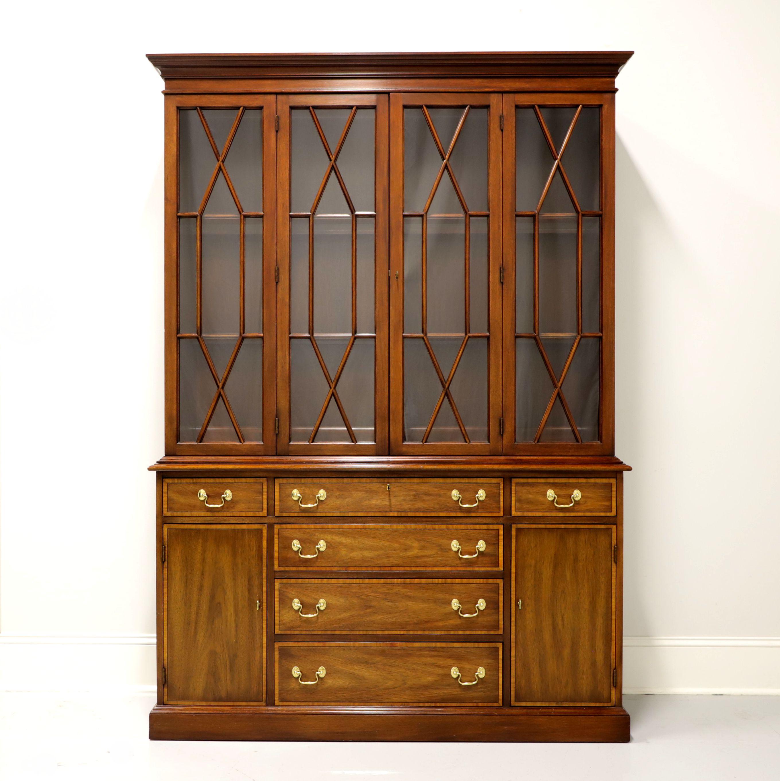 A Traditional style China cabinet by Henkel Harris of Winchester, Virginia, USA. Banded mahogany with brass hardware. Top cabinet is lighted and has two fixed wood plate grooved shelves with glass inserts behind two lockable glass doors with