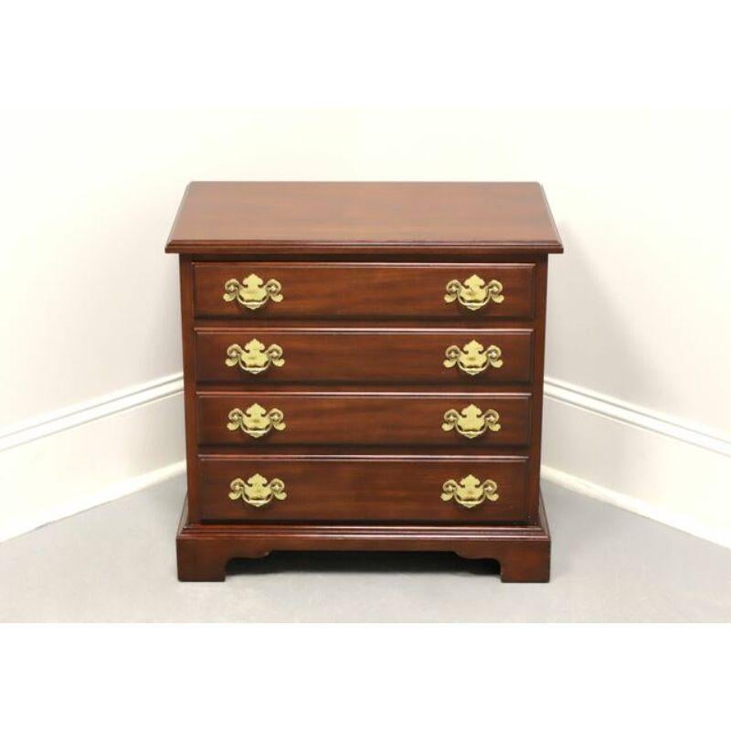 A Chippendale style chairside chest by Henkel Harris. Solid Wild Black Cherry with bevel edge to the top, brass hardware, side handles, fully finished back, and bracket feet. Features four drawers of dovetail construction. Made in Winchester,