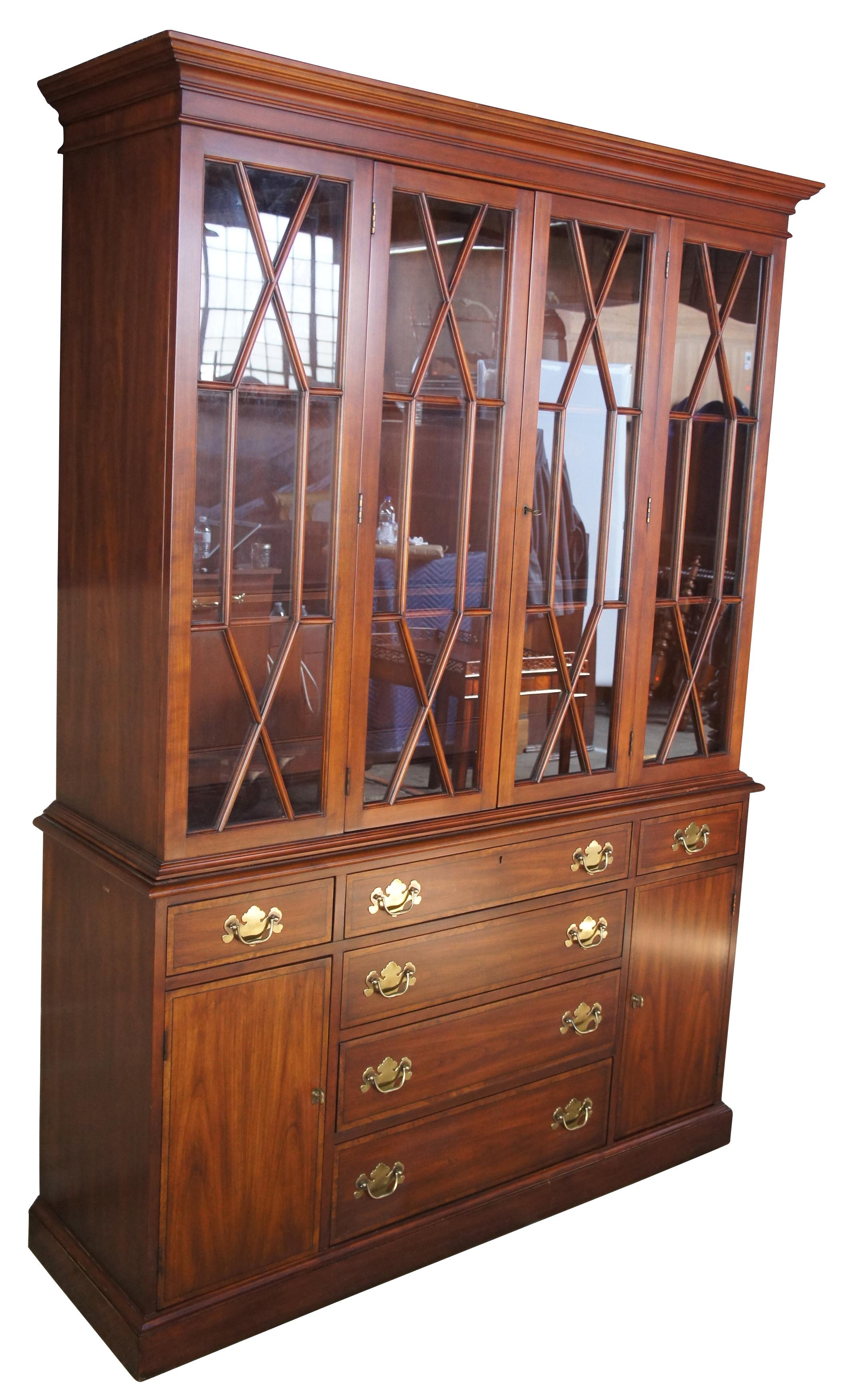 Henkel Harris wild black cherry china cabinet with lattice covered glass doors, circa 1980s. A beautiful reproduction of 18th century styling. Features six drawers (one with silverware cloth) and two lower cabinets with shelves. Stunning cherrywood