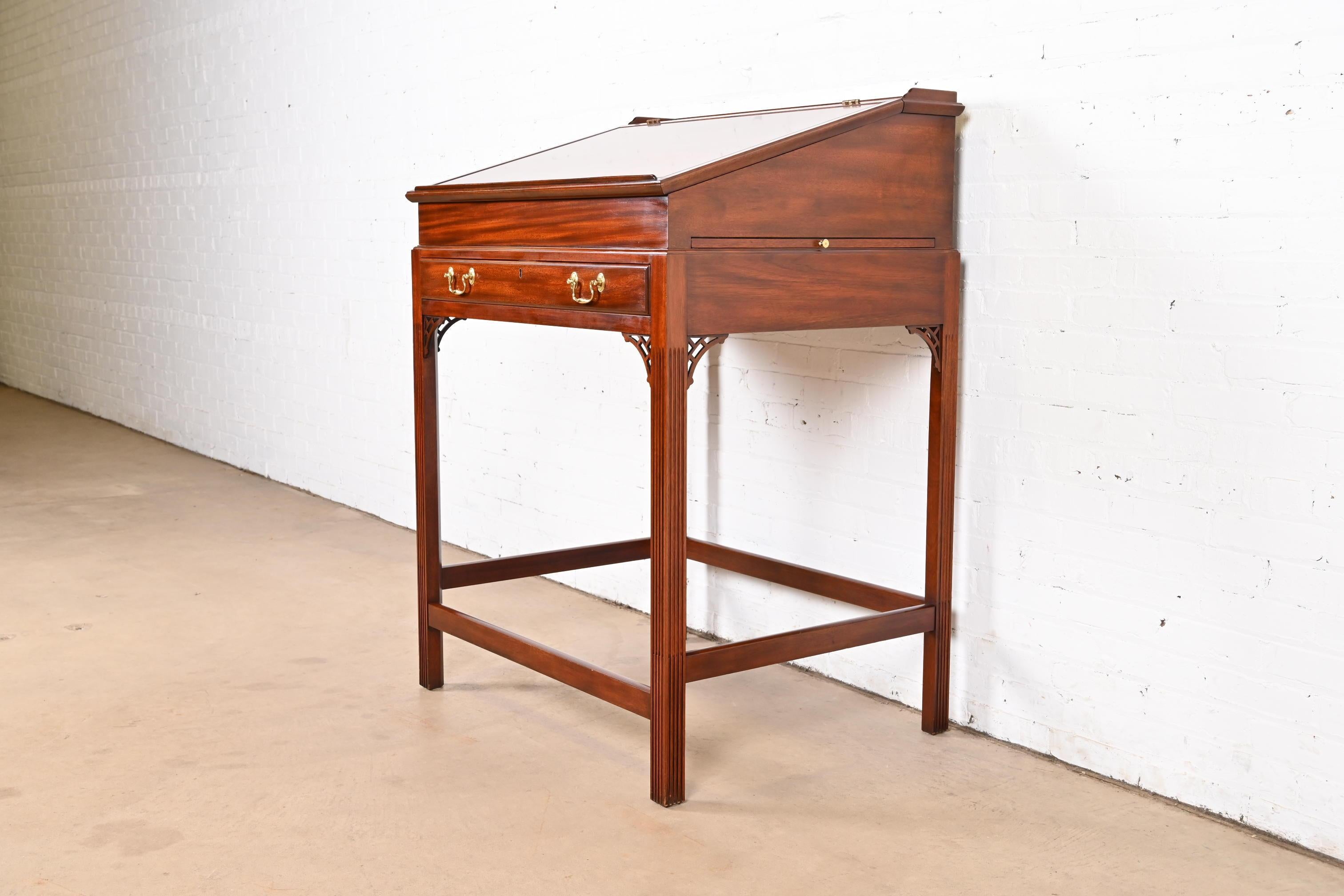 A gorgeous Georgian or Chippendale style slant front standing desk or architect's desk

By Henkel Moore

USA, Late 20th Century

Carved mahogany, with original brass hardware. Drawer locks and key is included.

Measures: 36