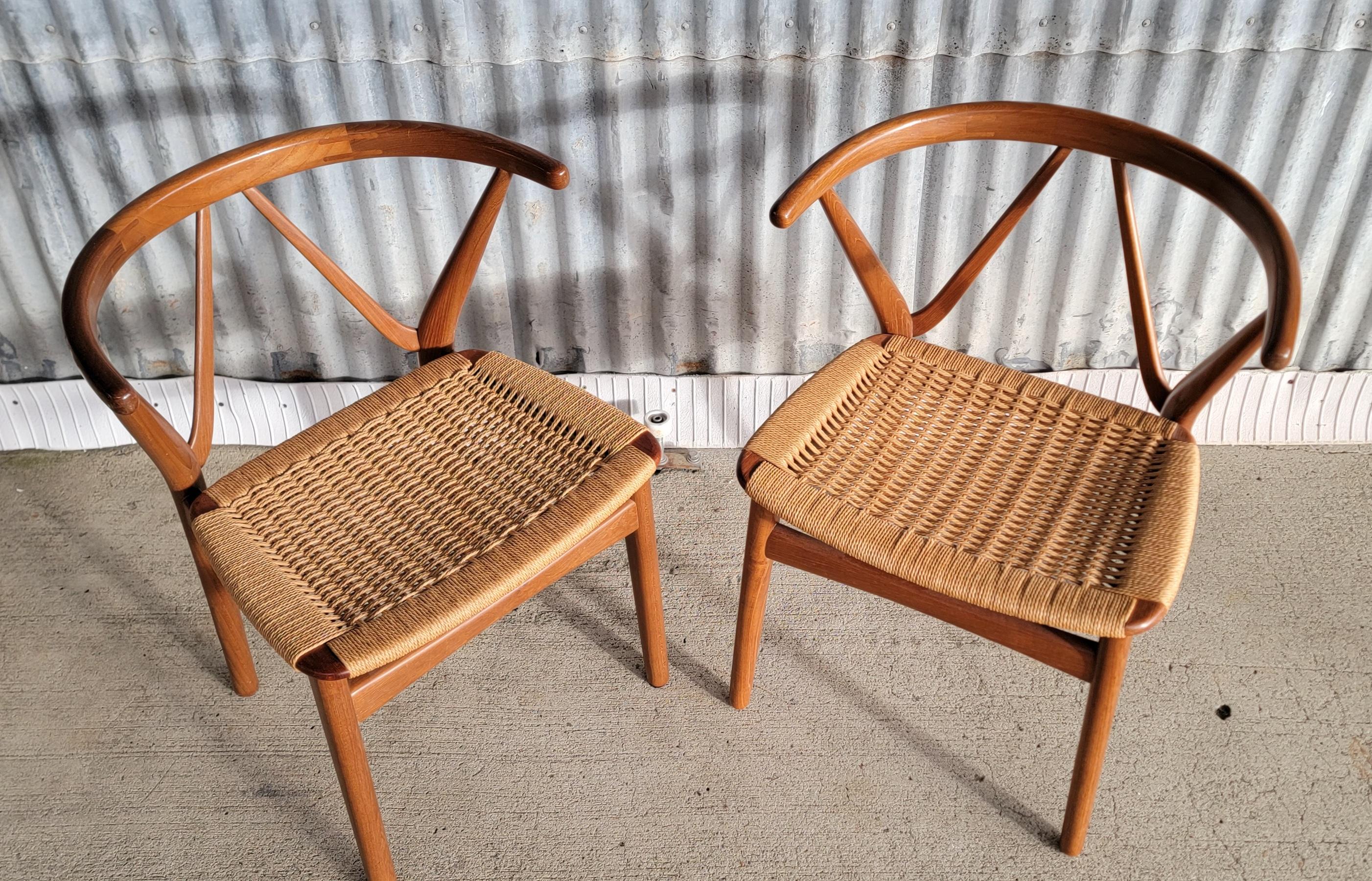 A pair of teak and paper cord dining armchairs designed by Henning Kjaernuff for Bruno Hansen. Denmark. Circa. 1960. Makers mark stamped on chair frame. Original paper cord seats are worn and have broken cords. Replacement recommended soon or add