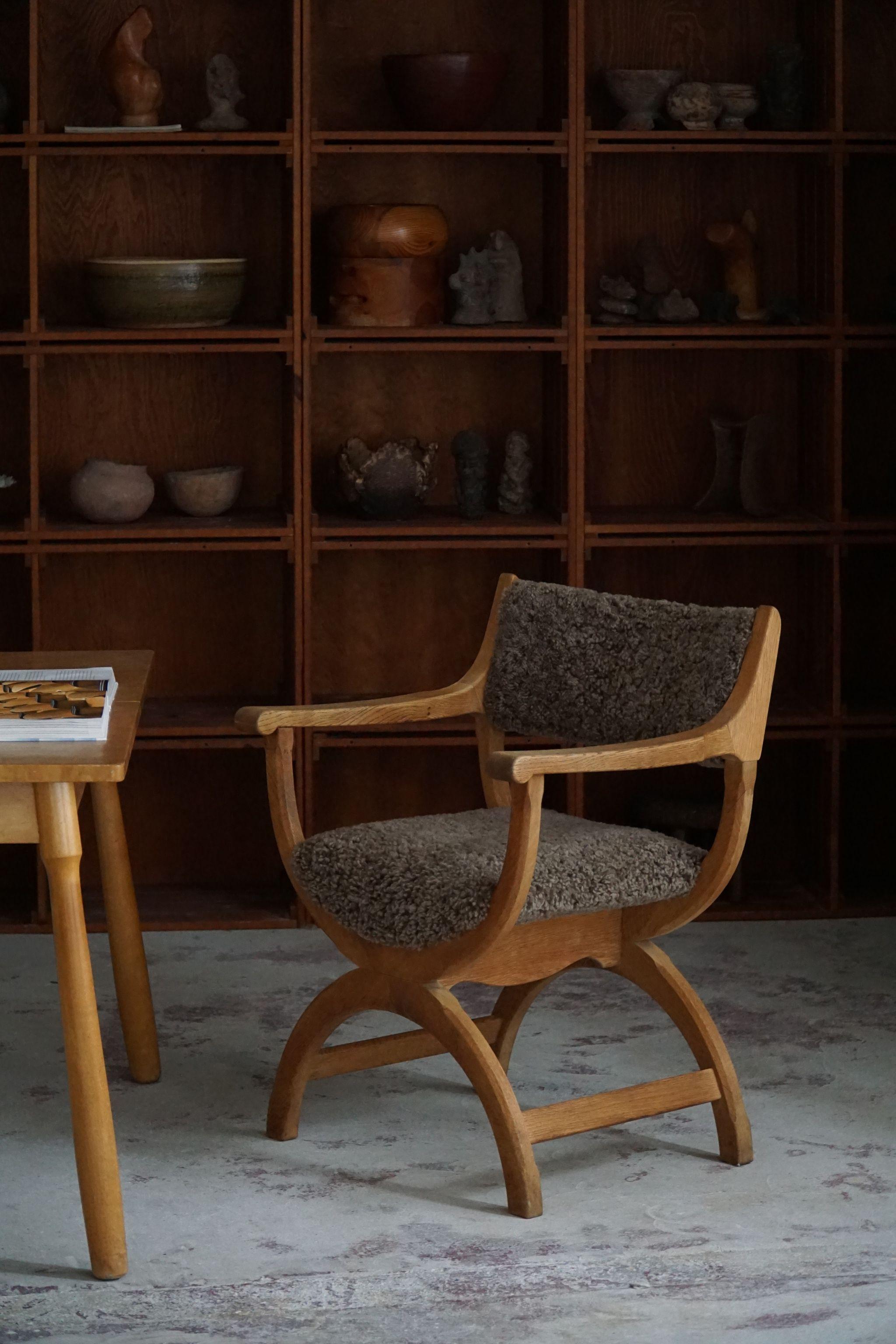 A fine and elegant armchair in solid oak, reupholstered in quality shearling lambswool. Designed by Henning (Henry) Kjaernulf for EG Kvalitetsmøbel, Denmark 1960s. Model 
