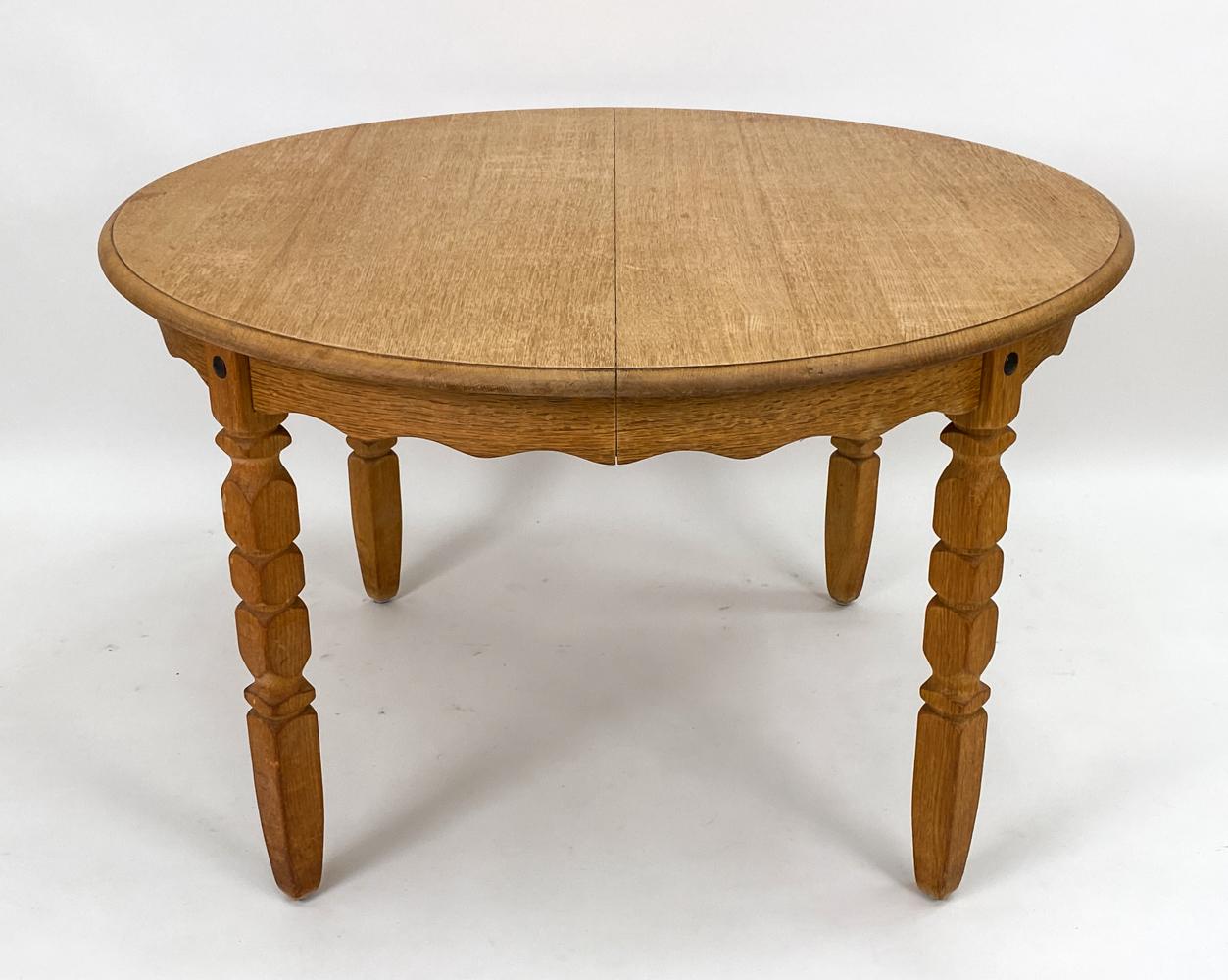 A Danish modern dining table in carved oak, designed by Henning Kjaernulf. No apparent labels. This Scandinavian modern table leans toward traditional farmhouse organic design making it a versatile piece for a multitude of interior aesthetics.