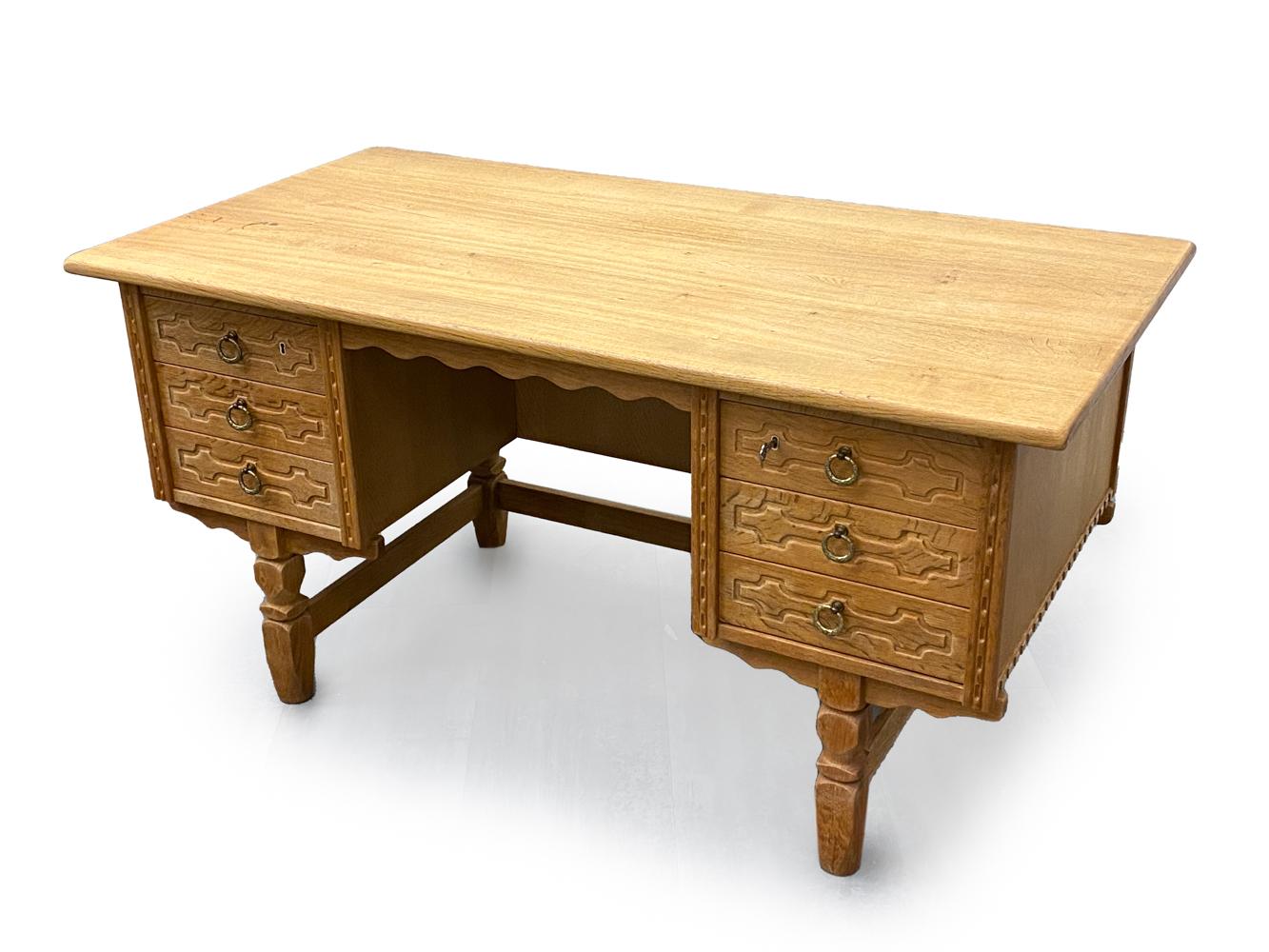Step into a world where functionality meets artistry with the Henning Kjaernulf Danish Mid-Century Carved Oak Desk. Crafted during a time when every piece was a labor of love and a reflection of impeccable taste, this desk stands as a paragon of