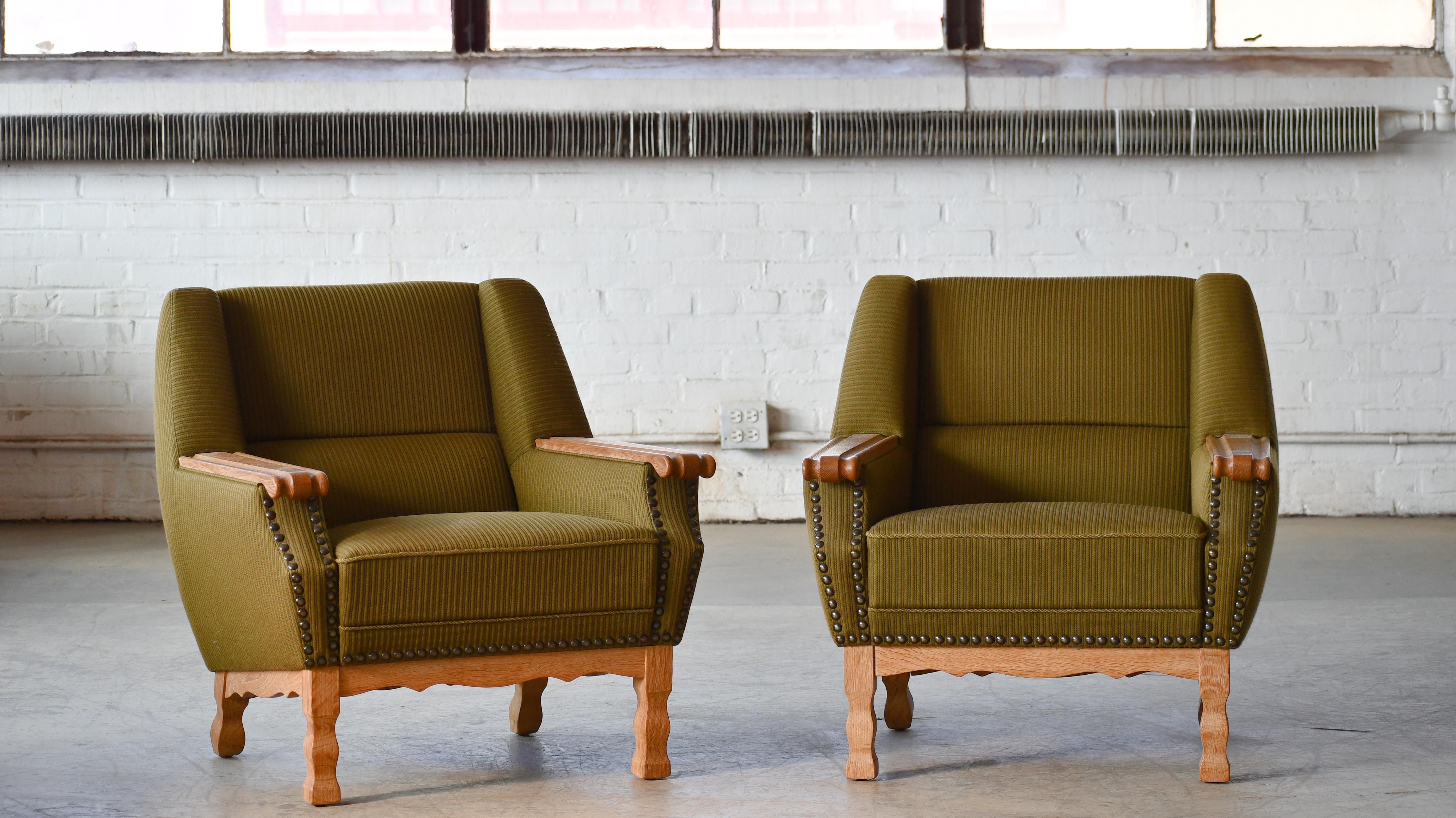 Rare and sought after pair of  lounge chairs by Danish Designer, Henning Kjaernulf made from quarter-sawn white oak and hand carved in brutalist style seeking inspiration from art & crafts and even Jacobean styles. Kjaernulfs style is very unique