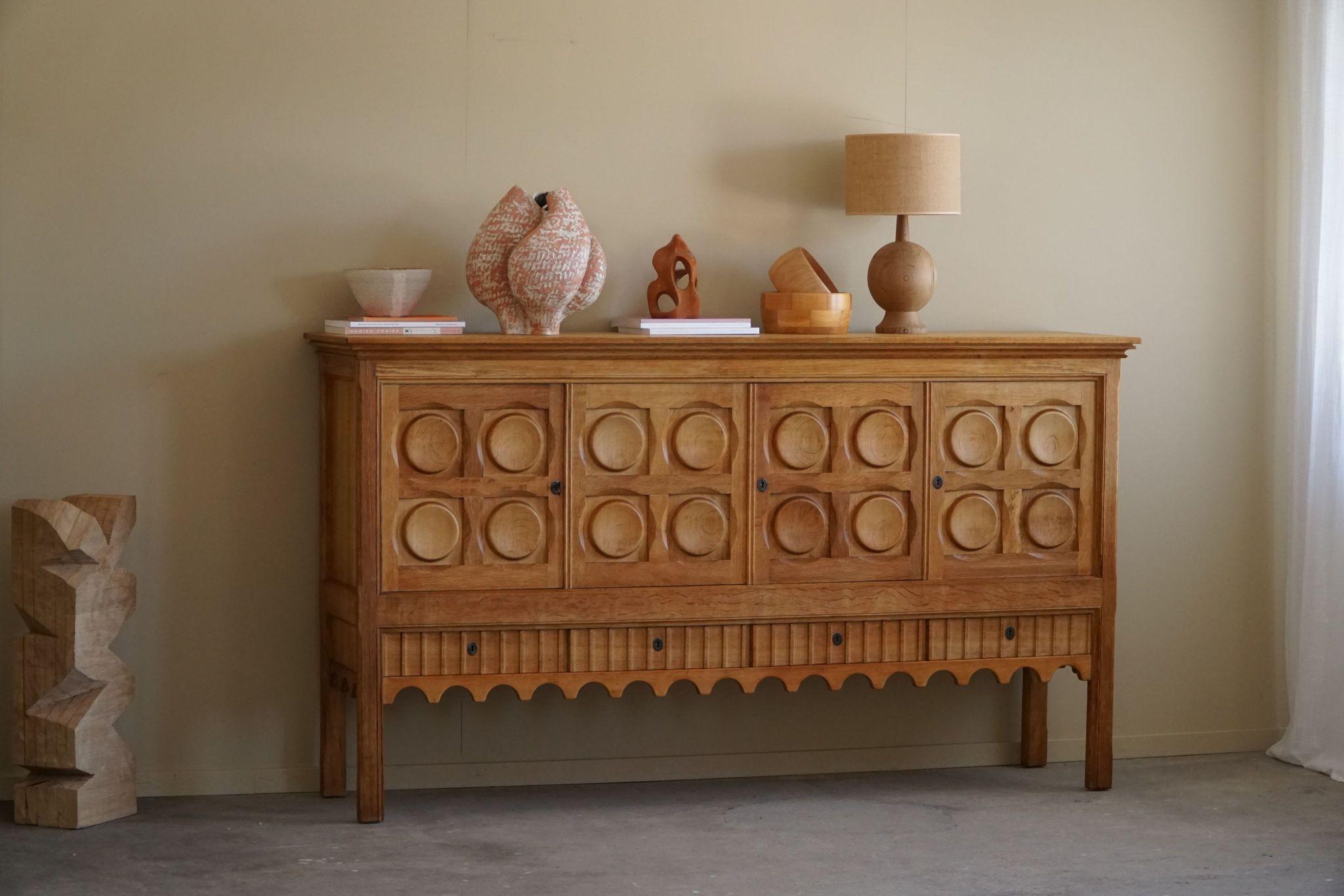 A classic rectangular sideboard / cabinet in oak with plenty of storage and a nice carved front design. Designed by Henning (Henry) Kjærnulf for Nyrup Møbelfabrik in the 1960s. Crafted from oak, the sideboard features a robust and imposing presence,