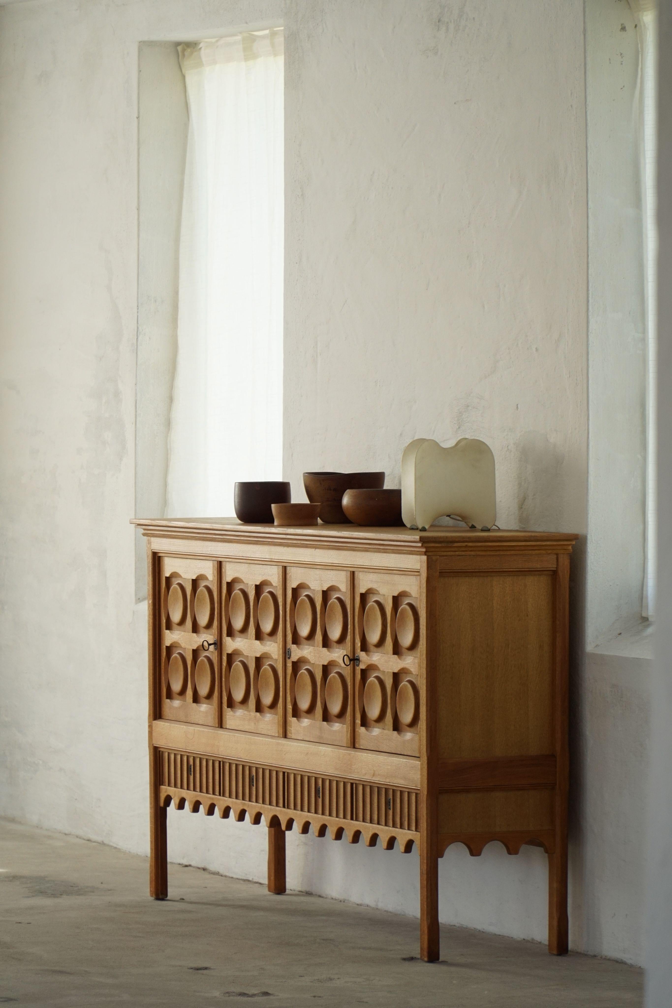Un buffet rectangulaire classique en chêne massif avec de généreux rangements et une façade magnifiquement sculptée. Conçue par Henning (Henry) Kjærnulf pour Nyrup Møbelfabrik dans les années 1960, cette pièce est un bel exemple de sa capacité à