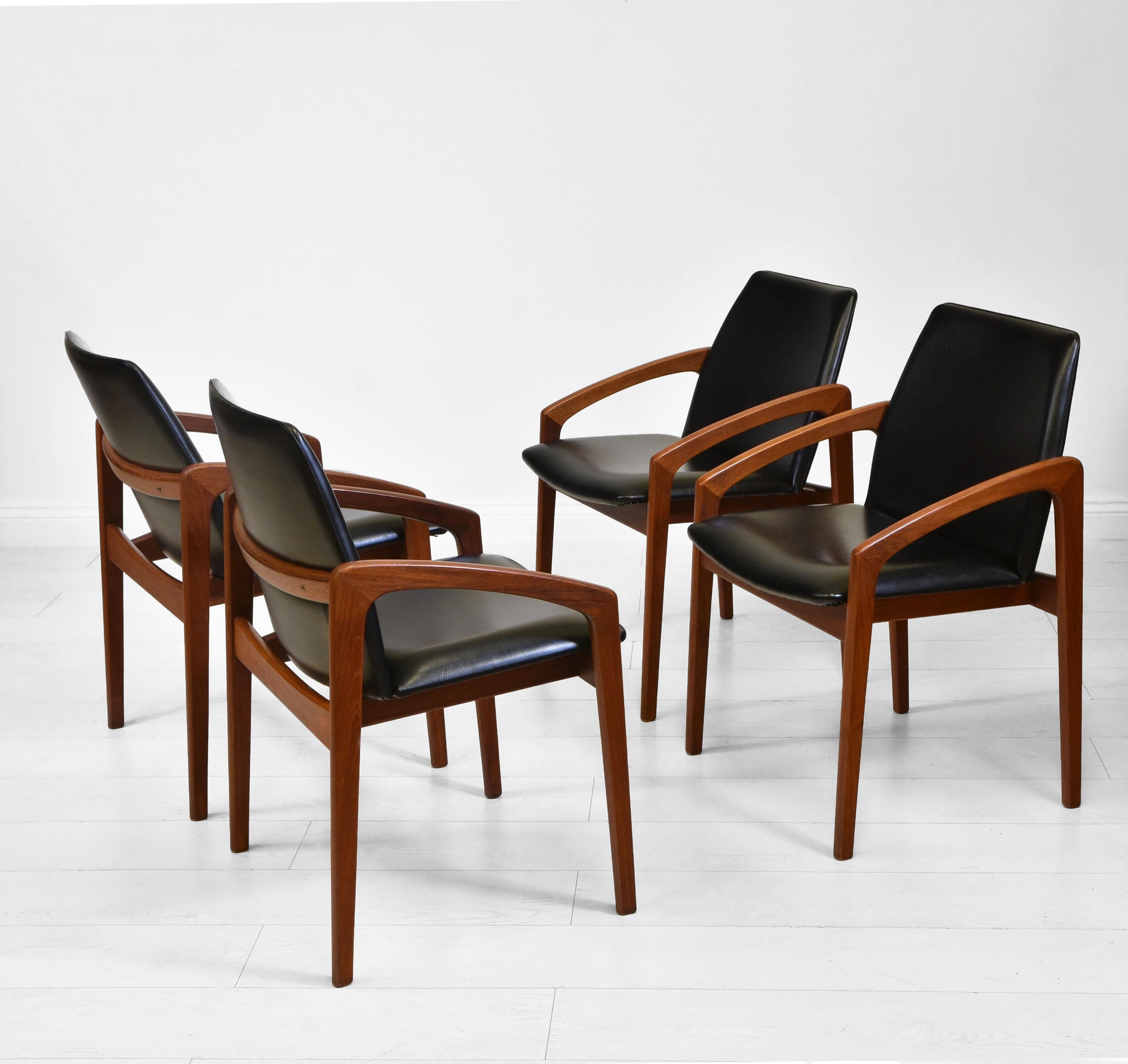 A stylish set of four Danish dining chairs designed by Henning Kjaernulf for Korup Stolefabrik. Circa 1960.

The chairs have solid teak frames with the original black vinyl seating. The seating is in very good condition, no rips or tears, and is