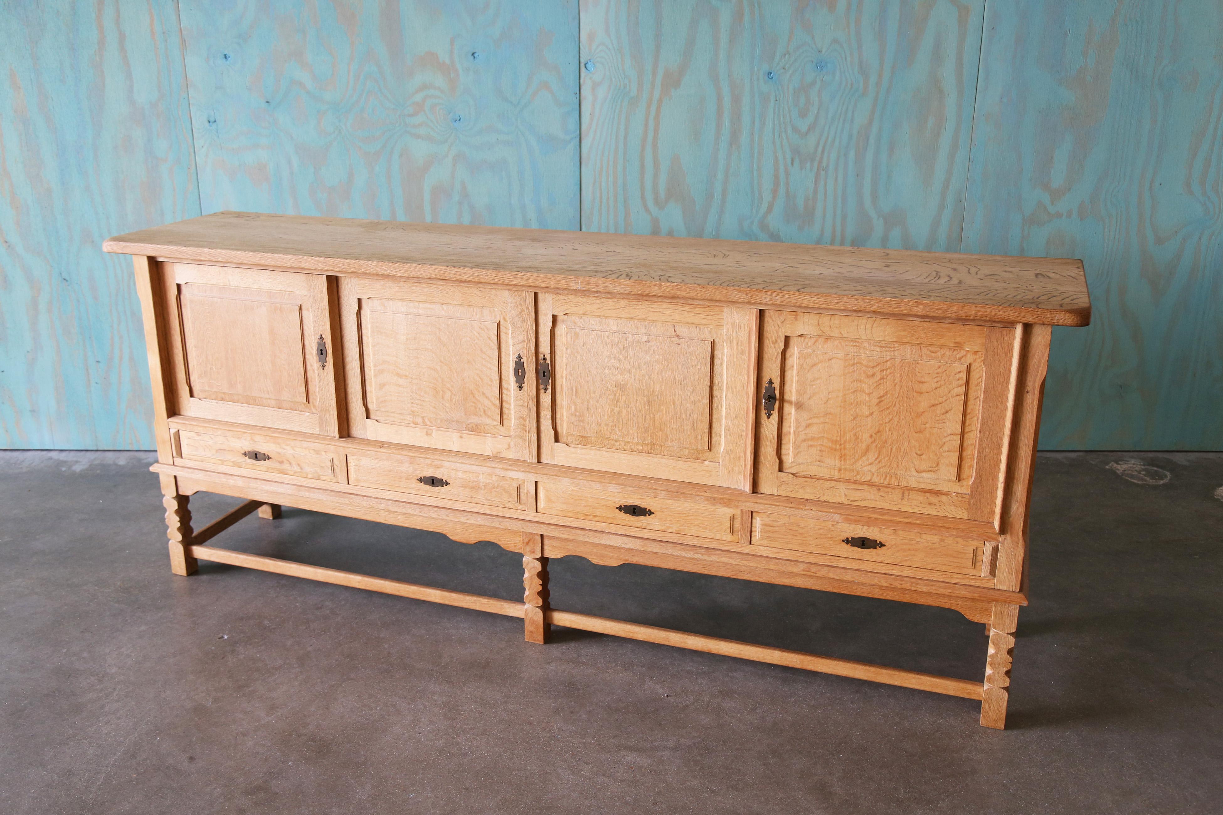 A monumental sideboard cabinet in the style of Henning Kjaernulf, made of solid quarter sawn oak, the rays and checks in the wood really dance on the top of this piece.  The oak provides great movement and an ode to true craftsmanship. plenty of