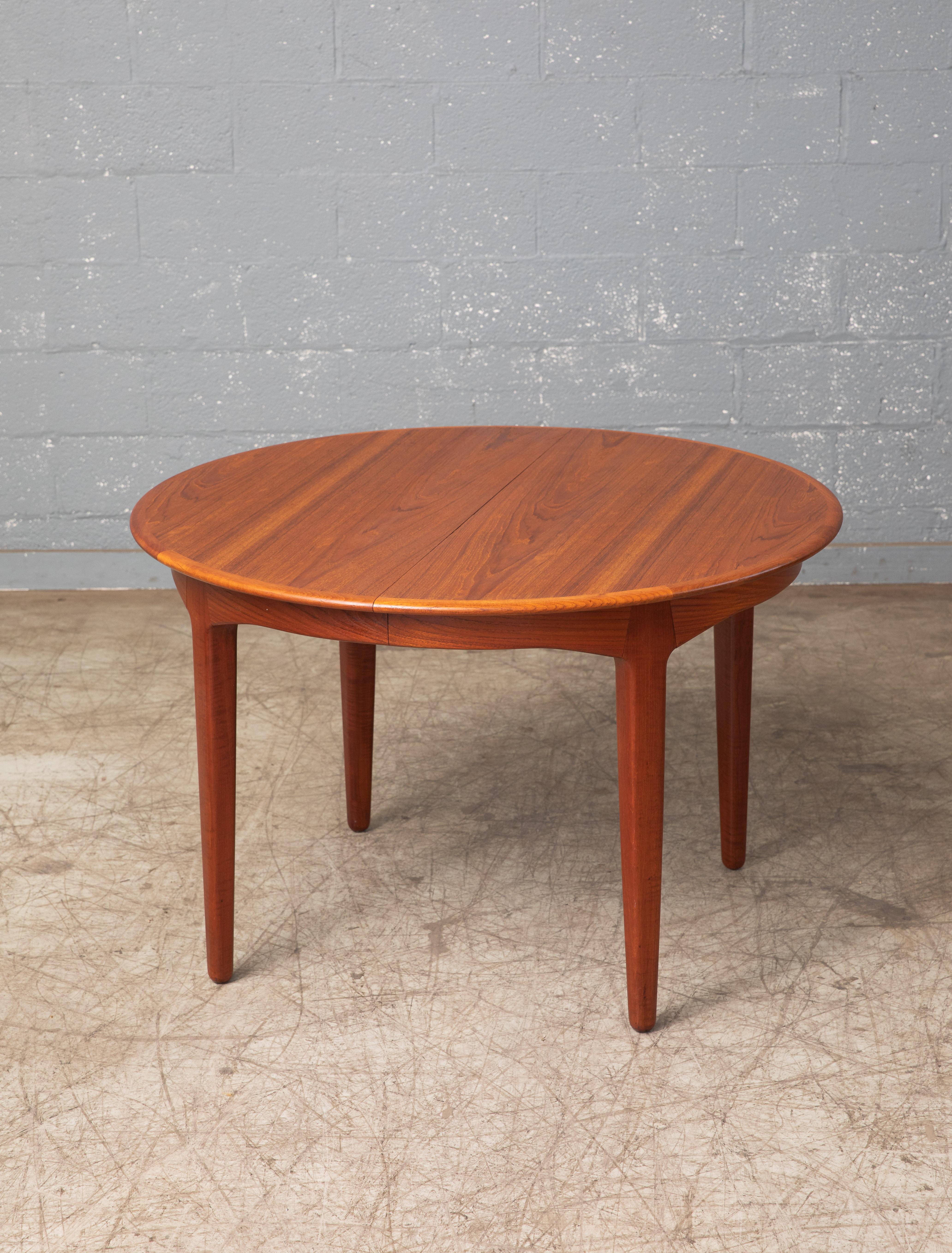 Beautiful round dining table in teak designed by renowned designer Henning Kjaernulf for Sorø Stolefabrik in 1962. The round table has a diameter of 45 inches and comfortable seats four people and comes with three extension leaves each measuring