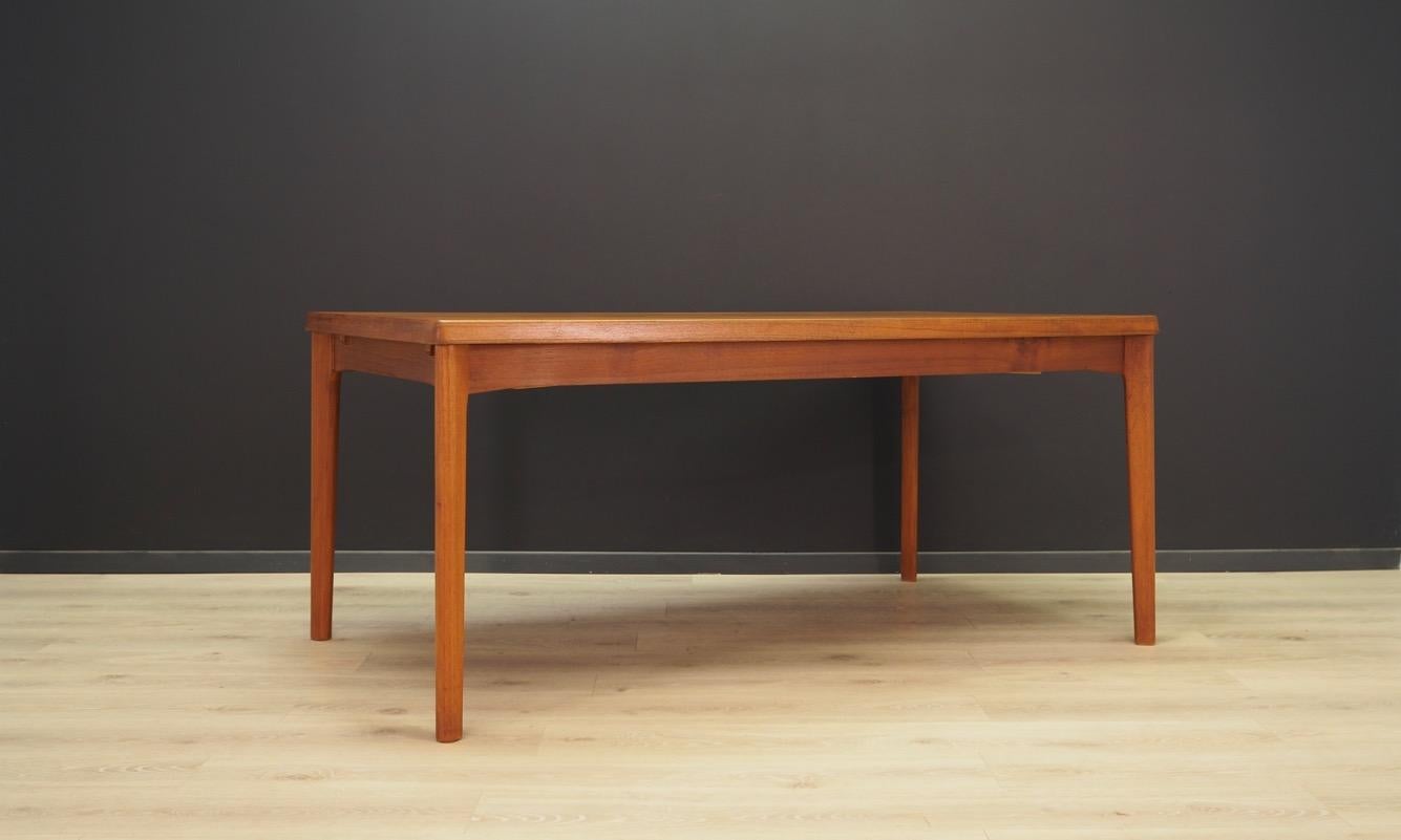 A fantastic table from the 1960s-1970s, designed by Henning Kjaernulf, manufactured by VEJLE STOLE OG. Table top finished with teak veneer, legs made of solid teak wood. The table has two extendable inserts under the table top. Maintained in good
