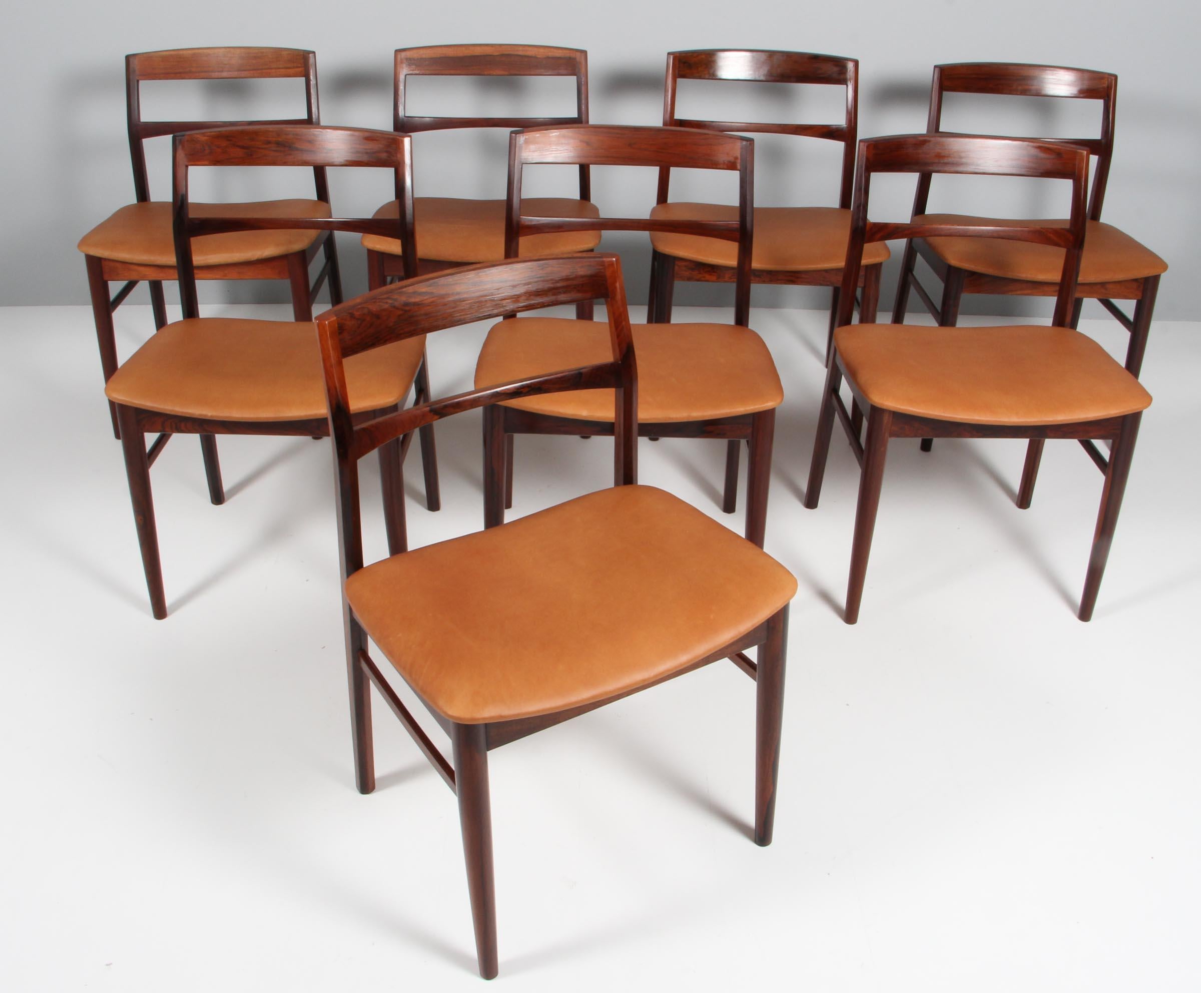 Henning Kjærnulf eight dining chairs, new upholstered with tan aniline leather.

Frame of solid rosewood.

Made by Vejle Stole & Møbelfabrik.