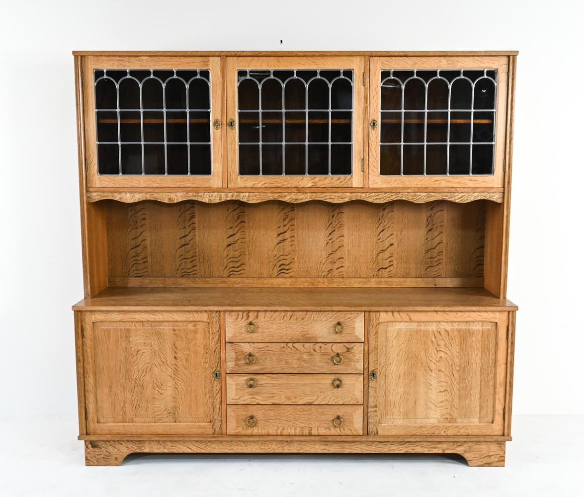 A gorgeous Danish mid-century farmhouse provincial-style cabinet composed of a sideboard base and a breakfront bookcase top with leaded glass doors, in two-part construction for easier transport. Finely crafted of sturdy, carved oak with unusual