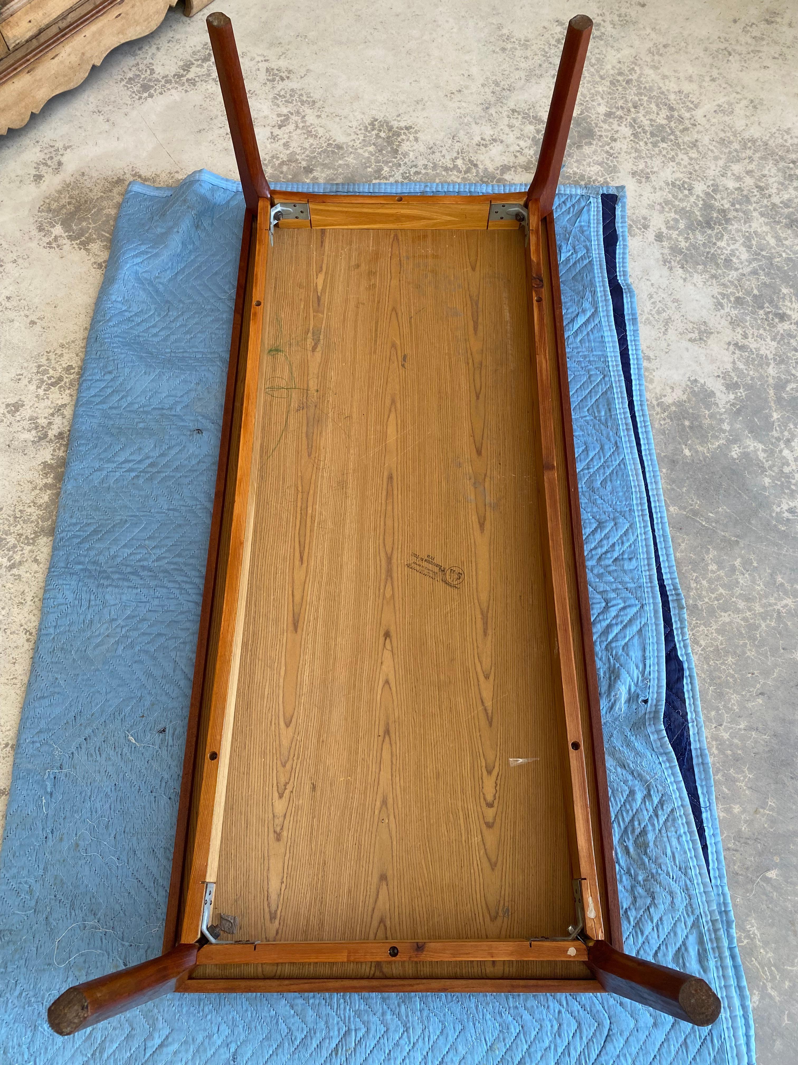 Henning Kjærnulf for Vejle Mobelfabrik (stamped to underside).

Solid teak coffee table with subtle and nuanced details. Notice the manner in which the edge tapers up to the surface from ever so slightly _ edges. The frame is inset, giving dimension