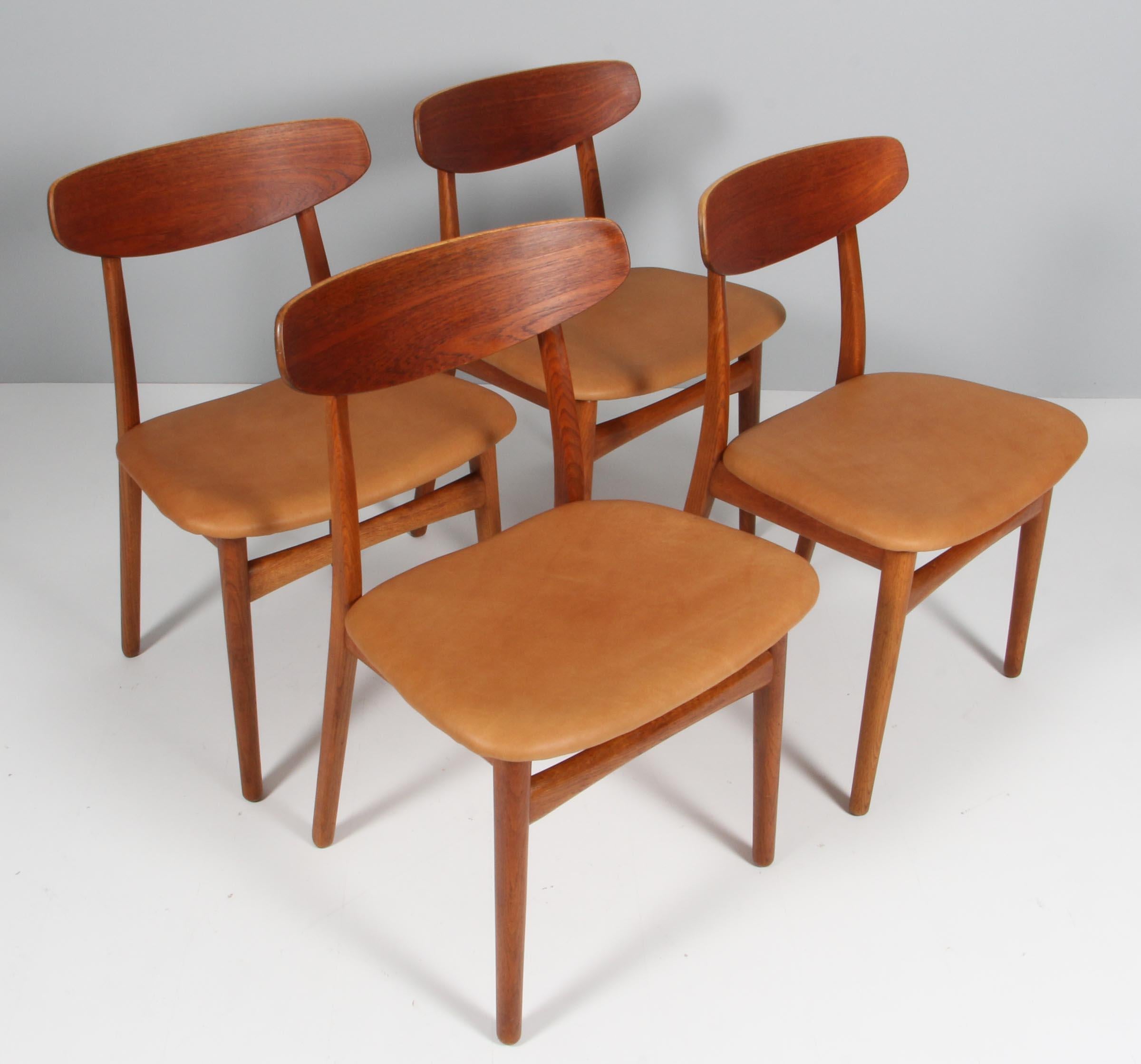 Henning Kjærnulf four dining chairs, upholstered with aniline leather.

Made of oak and teak.

Made by Bruno Hansen.