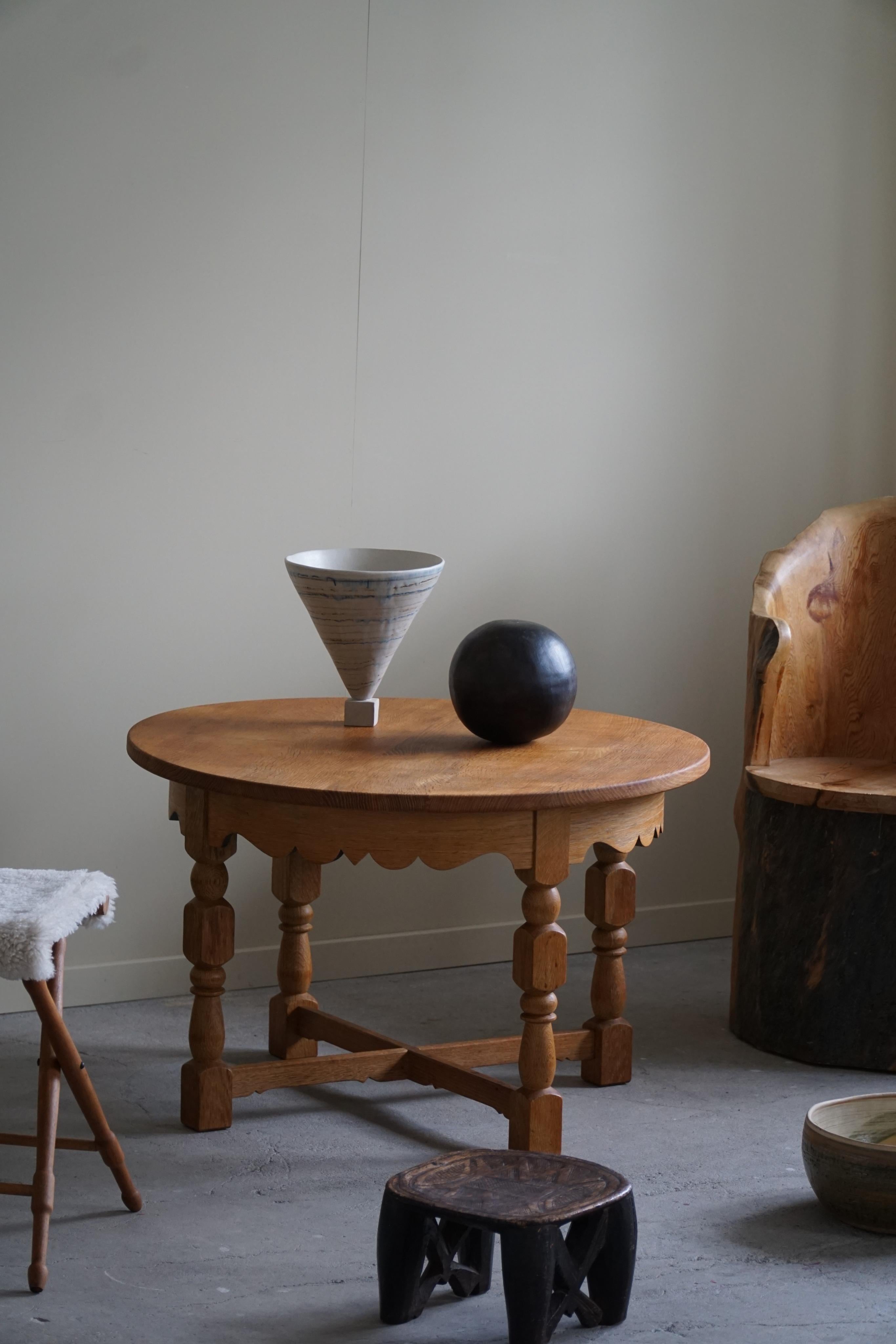 An intriguing side table in solid oak made in the 1960s by a Danish Cabinetmaker. Attributed to Danish architect Henning (Henry) Kjærnulf for Nyrup Møbelfabrik. 
The table's round silhouette exudes a sense of harmony and balance, while its