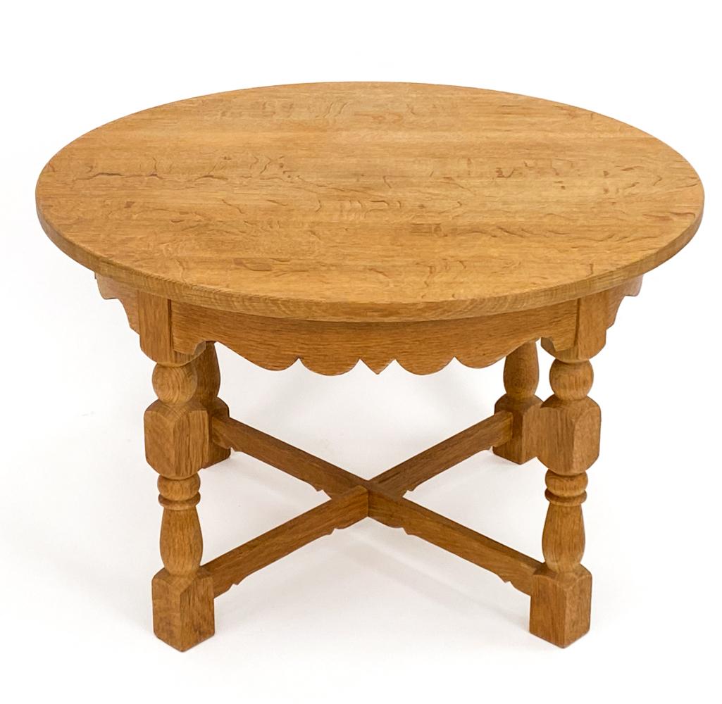 La table basse circulaire en chêne Henning Kjærnulf avec pieds sculptés est un mélange captivant d'artisanat, de beauté organique et d'expression artistique. Fabriquée par les mains expertes du designer danois Henning Kjærnulf, cette table basse