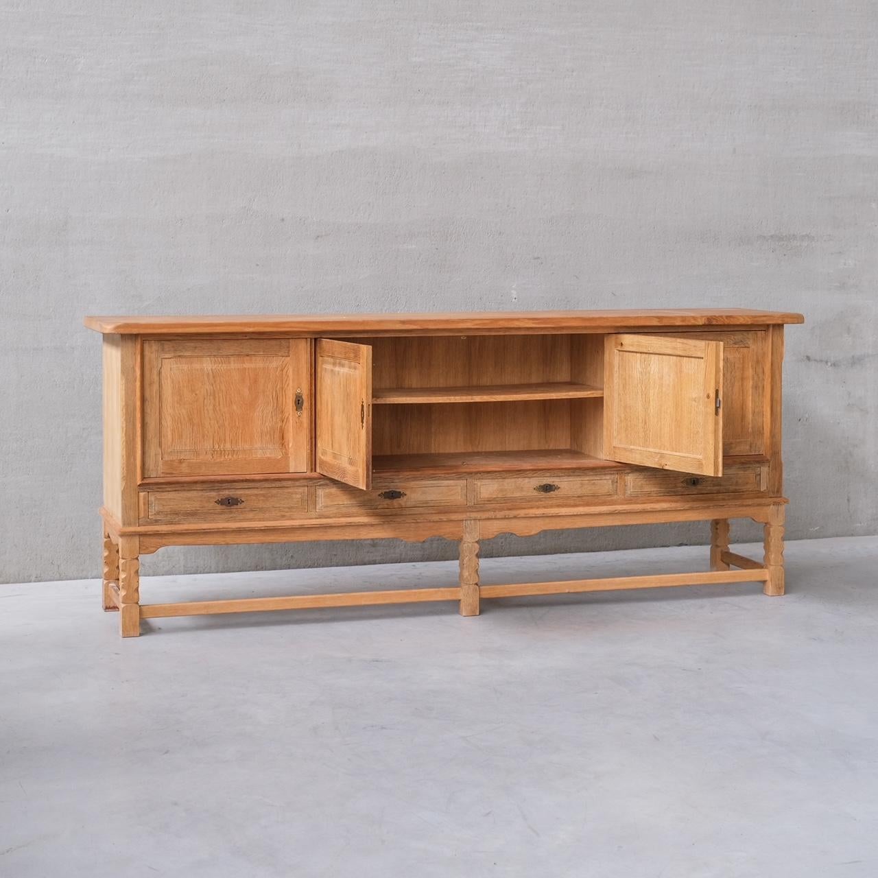 An oak sideboard by Henning (Henry) Kjaernulf.

Denmark, c1960s.

Cabinet doors over drawers.

Good vintage condition, some scuffs and wear commensurate with age.

Location: Belgium Gallery.

Dimensions: 92 H x 225 W x 50 D in