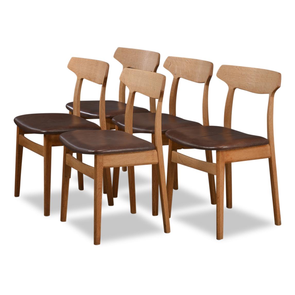 Set of five vintage dining chairs designed by Henning Kjaernulf voor Bruno Hansen. Stylish Mid-Century Modern top design that provides excellent seating comfort. The chairs feature a typically Danish organic design, solid oak frames and a dark brown